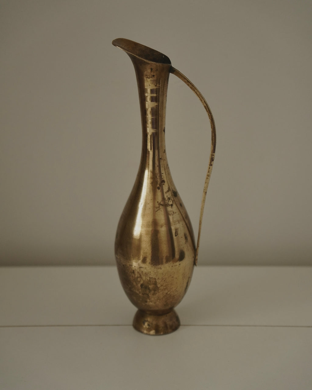 Tall brass vase with handle and tapered neck