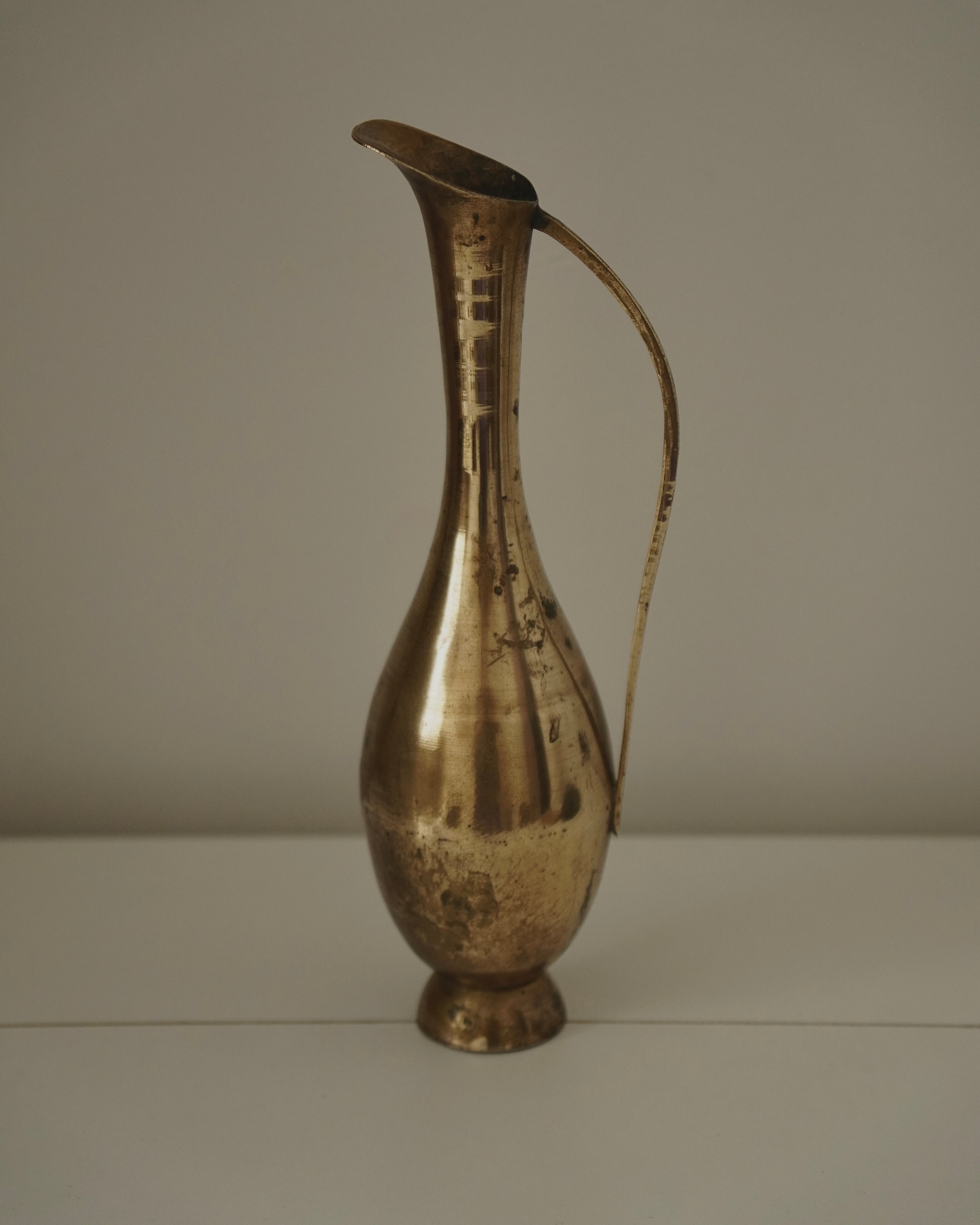 Tall brass vase with handle and tapered neck