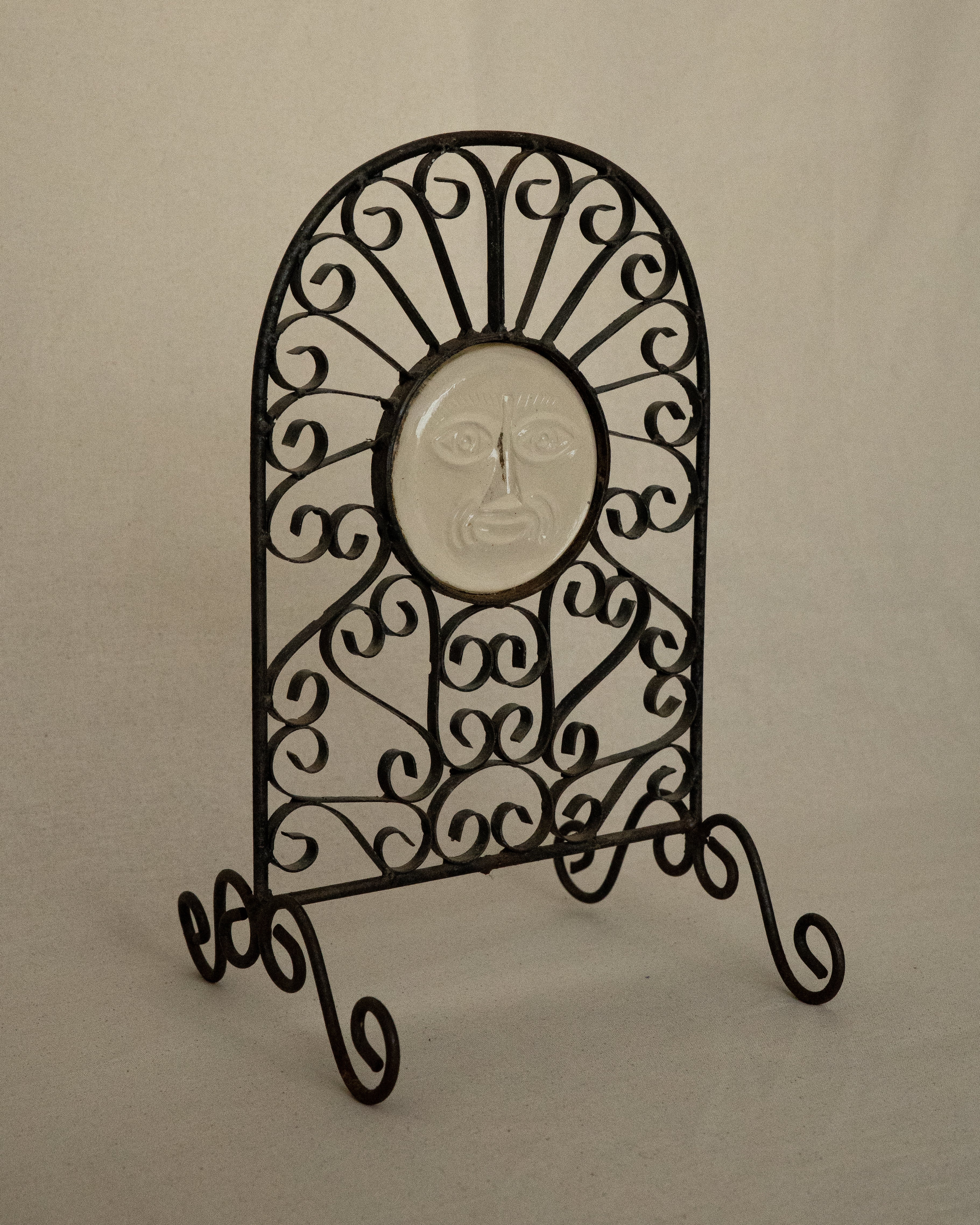 Glass sun face on metal spiral frame with feet