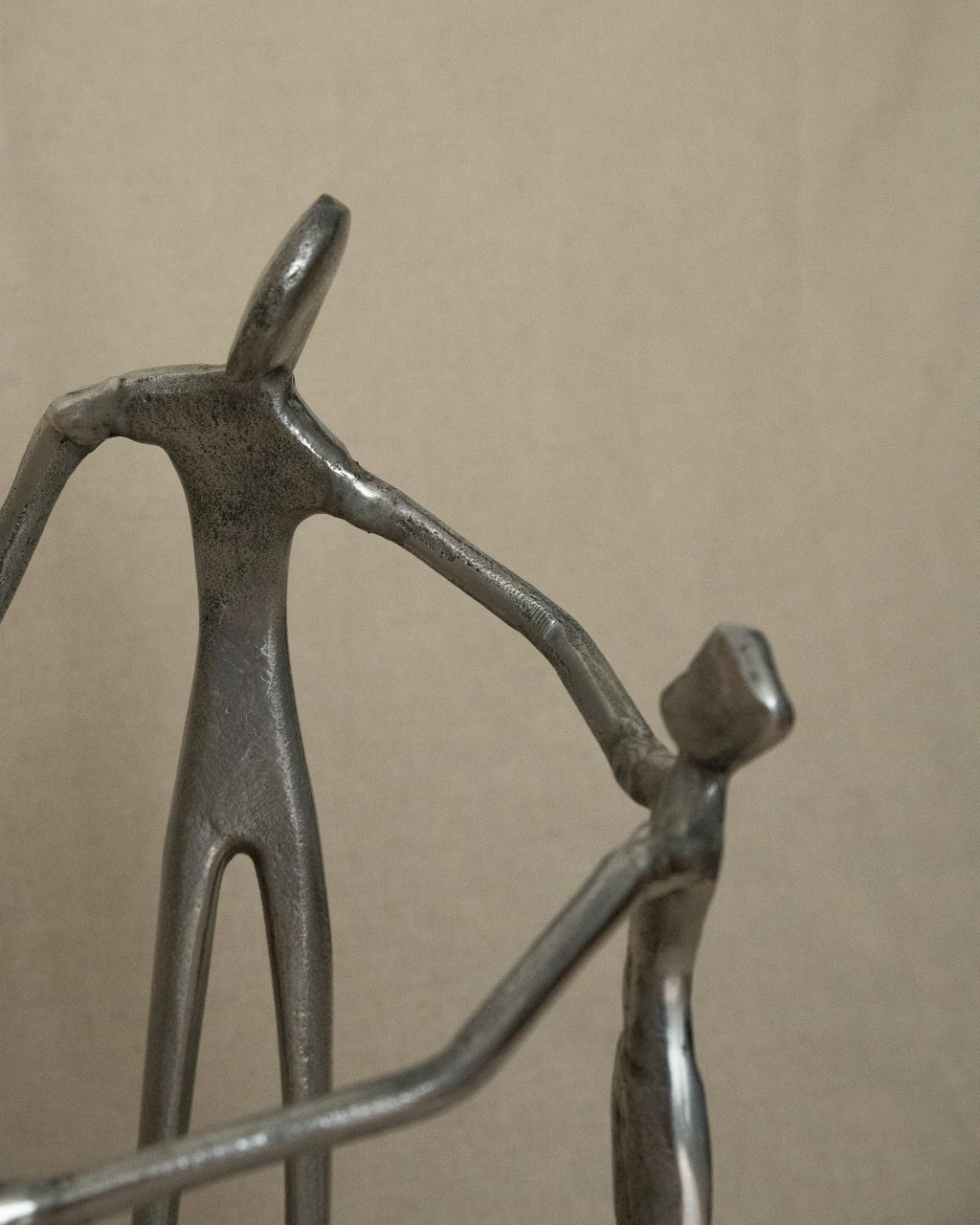 4 aluminum humans holding hands in a circle