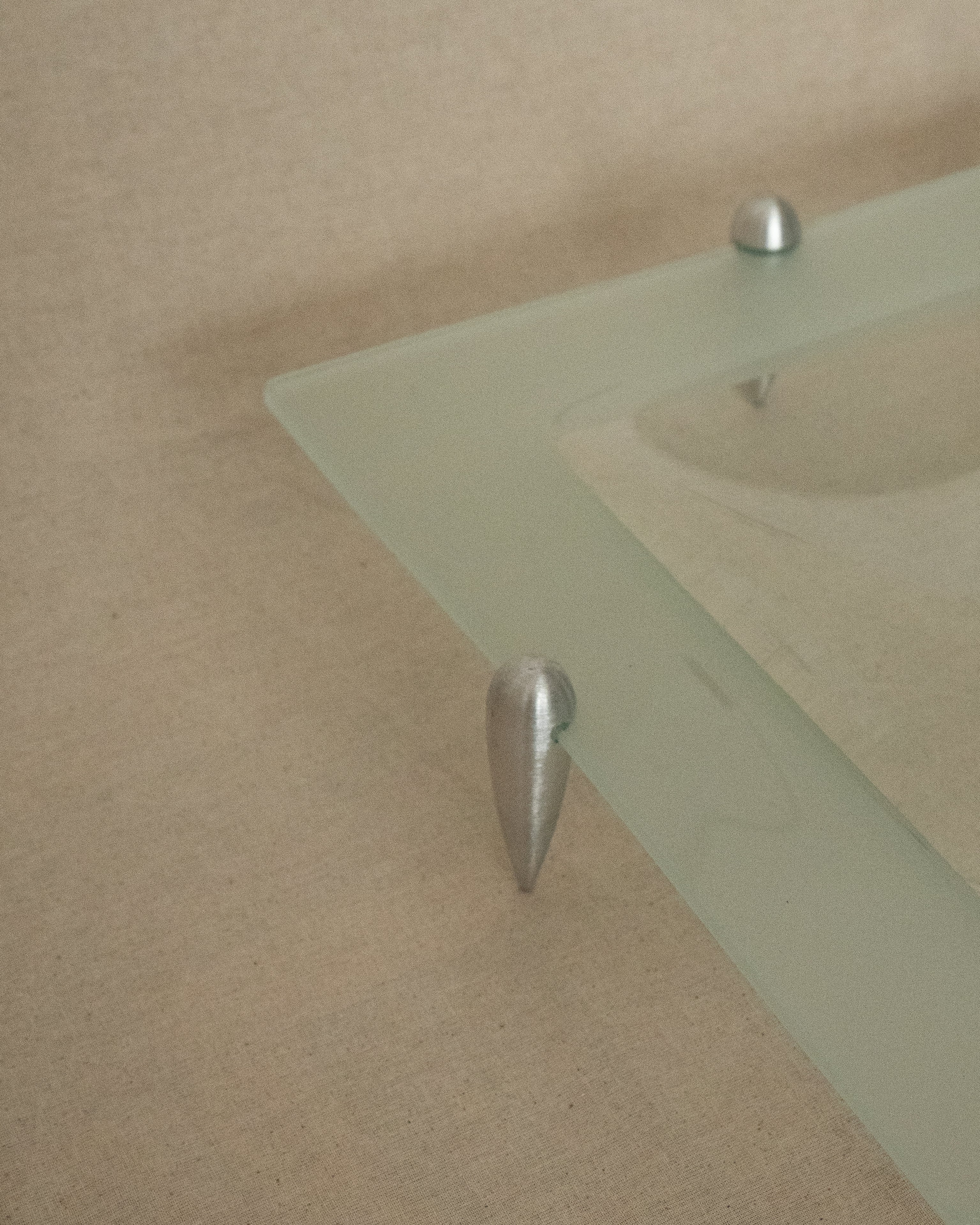 Glass square dish raised by atomic silver feet