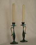 Pair of brass intentional verdigris single candle holders in the shape of vessels with handles