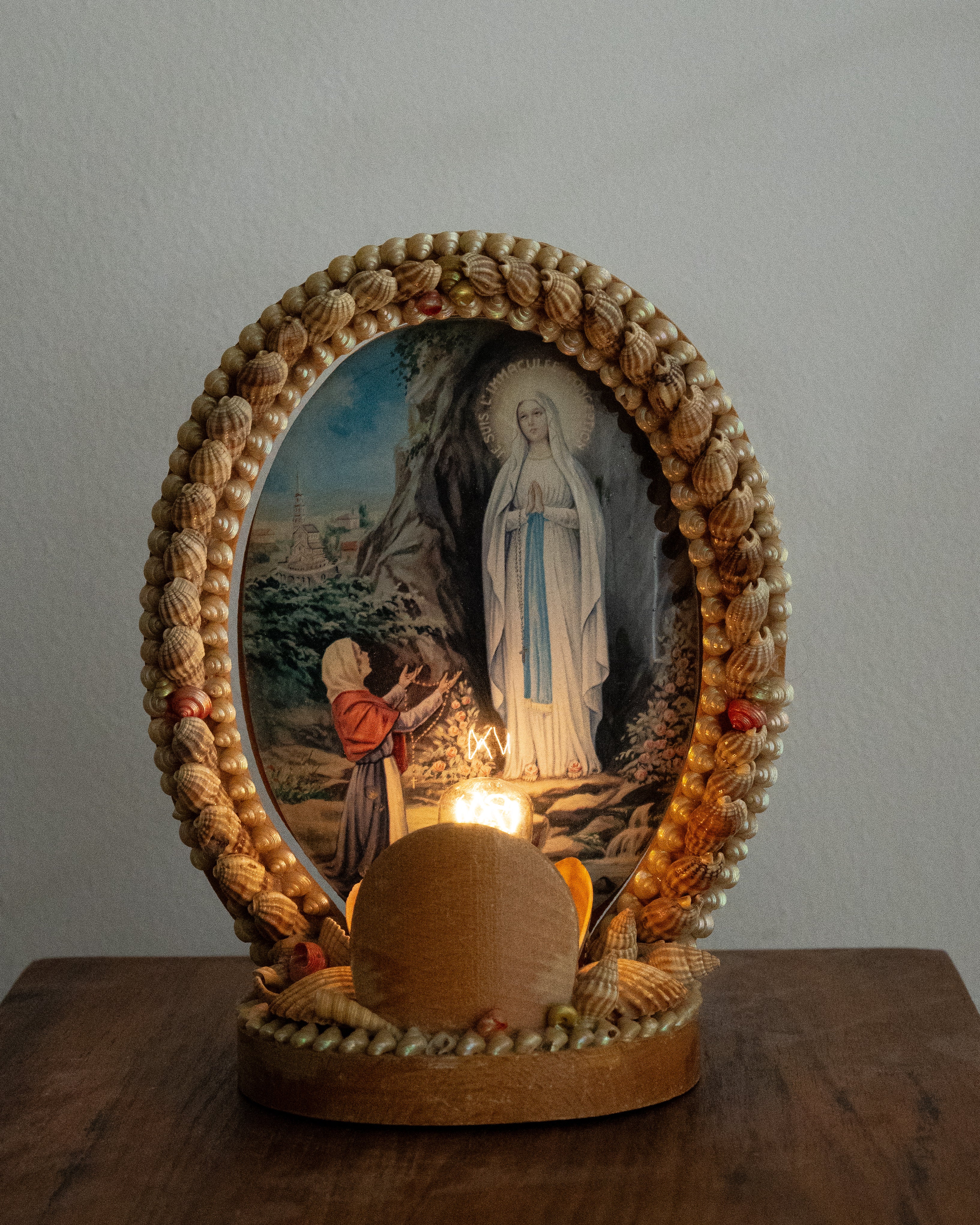 Shell table lamp encasing religious scene