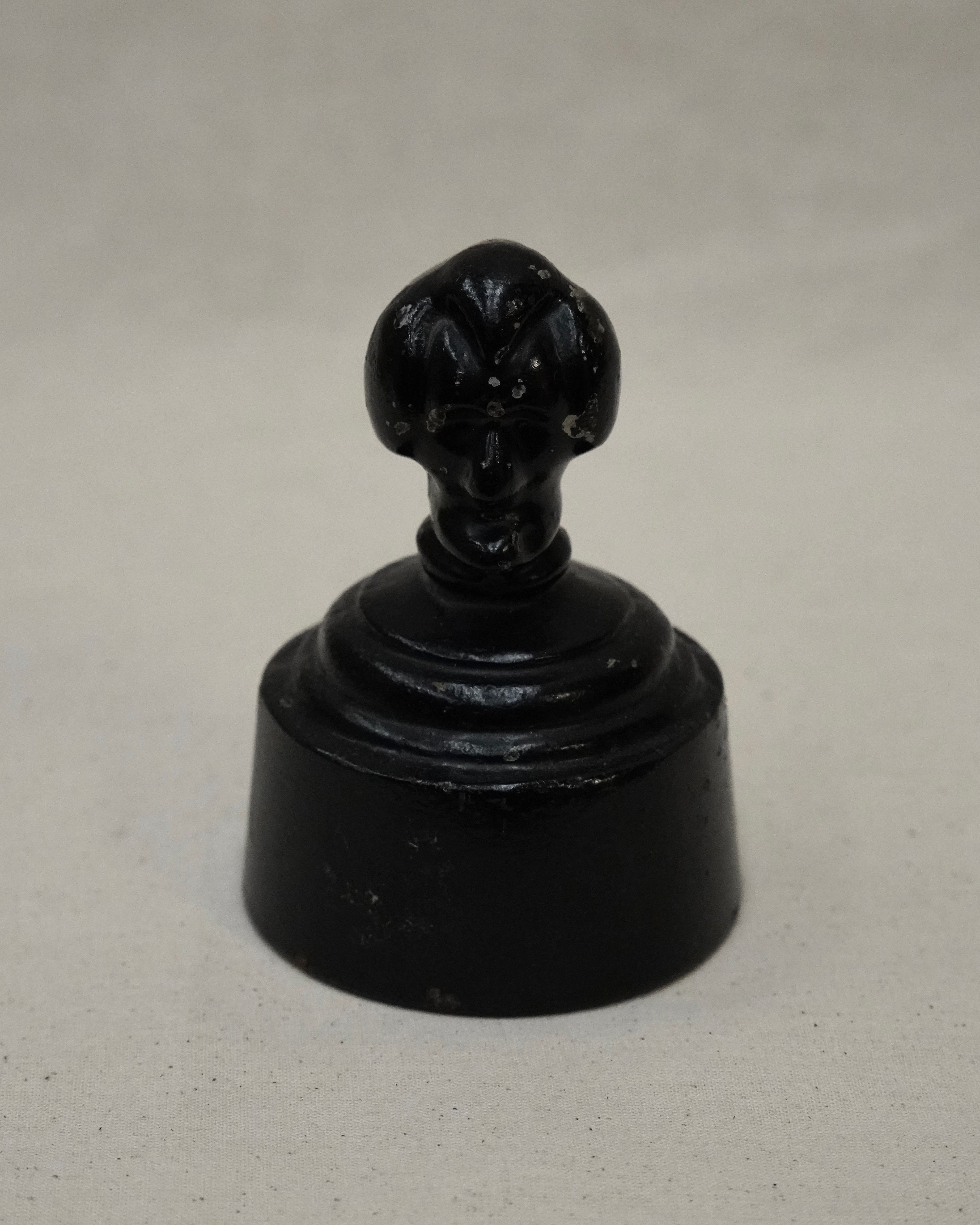 Metal paperweight of black head