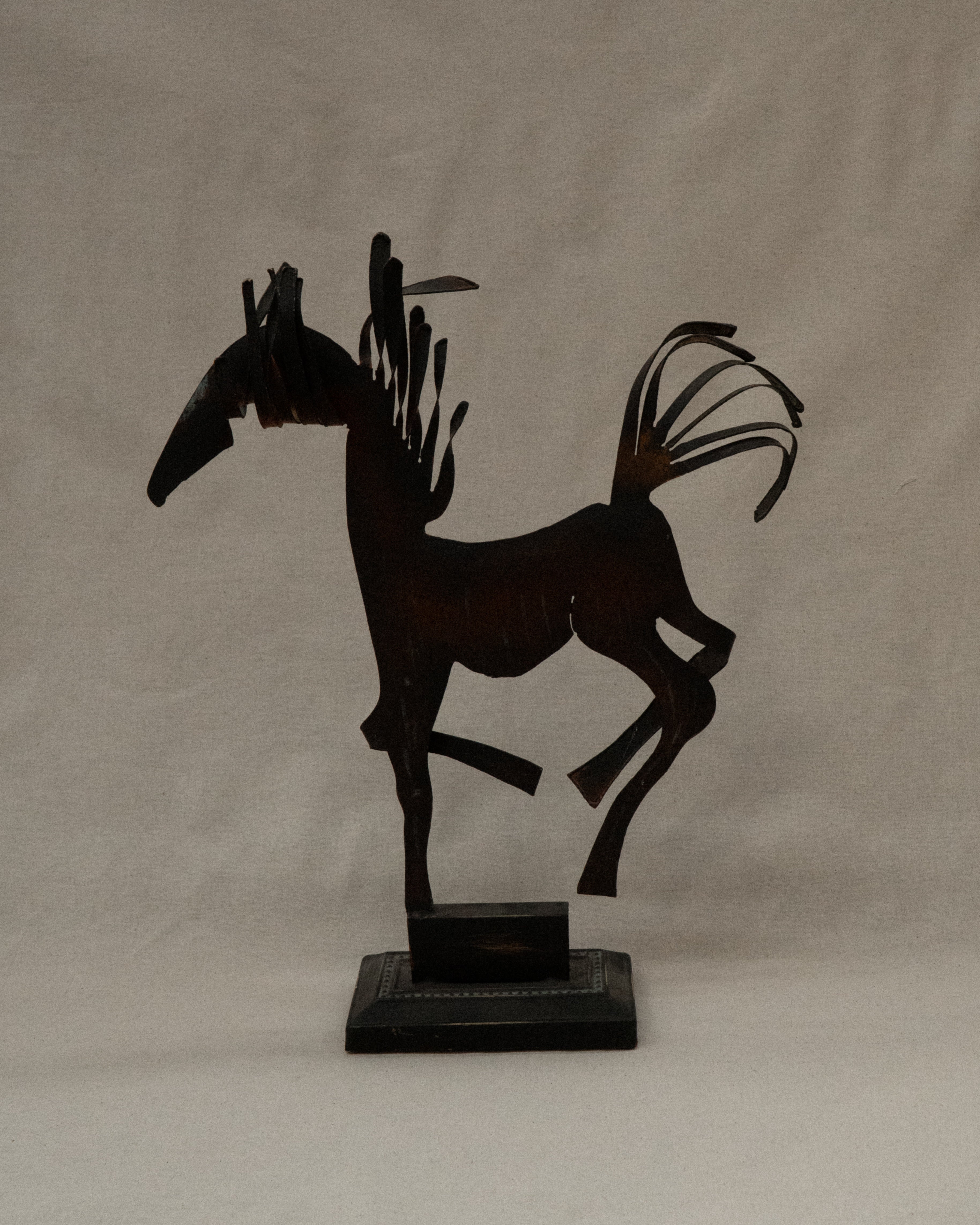 Brutalist metal horse sculpture with intentional patina