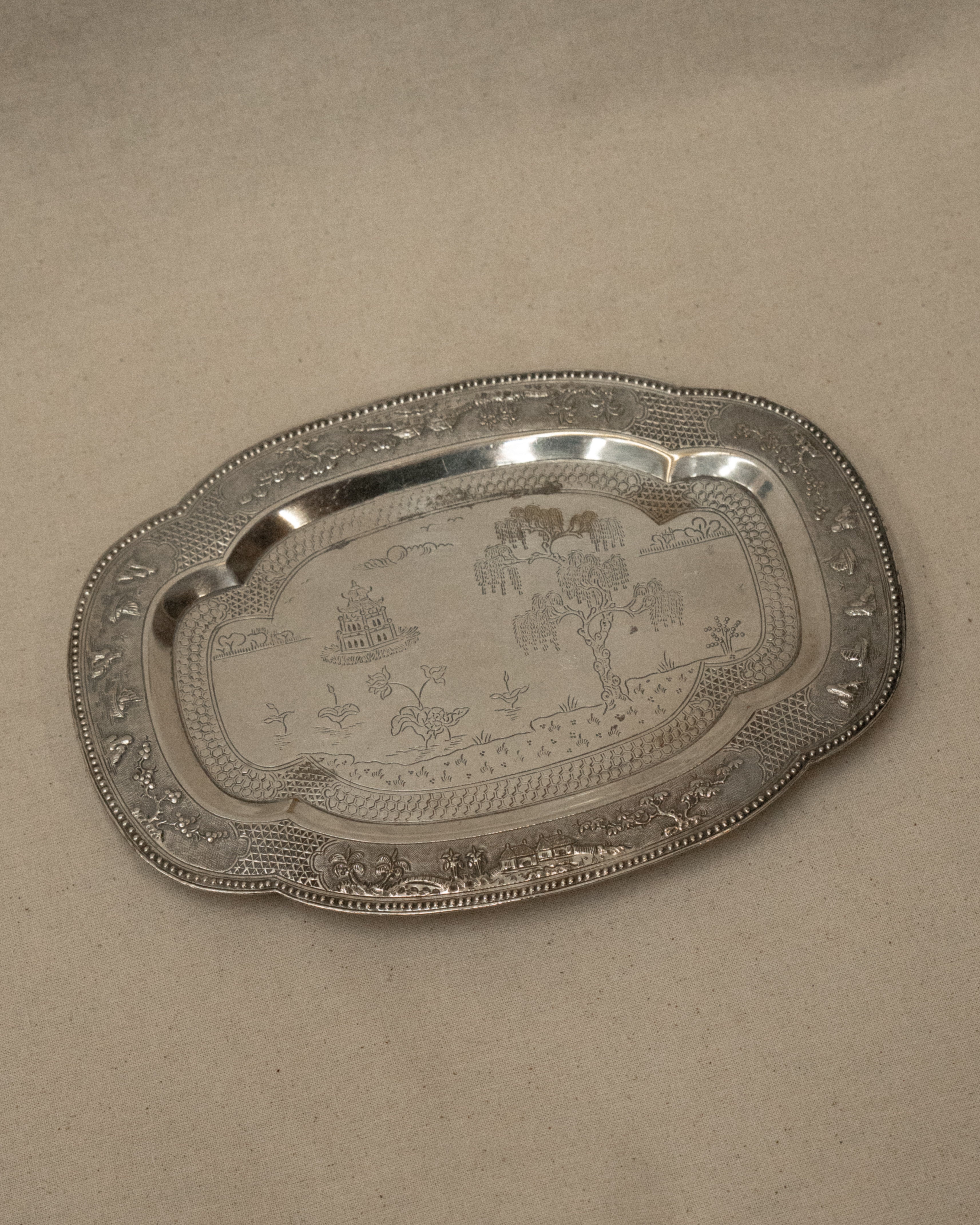 Metal tray with temple and tree engravings on feet