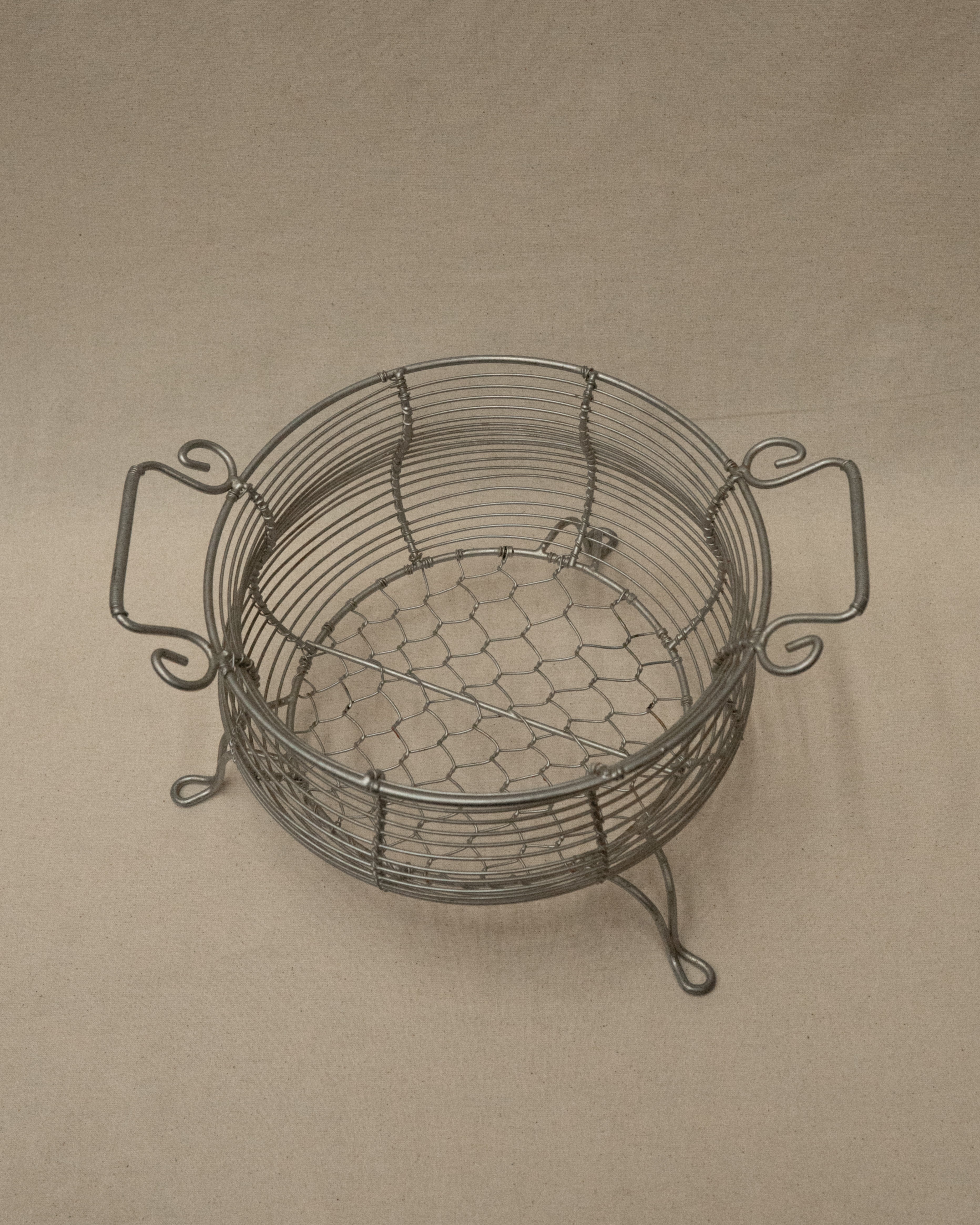 Wire metal basket with two handles and feet