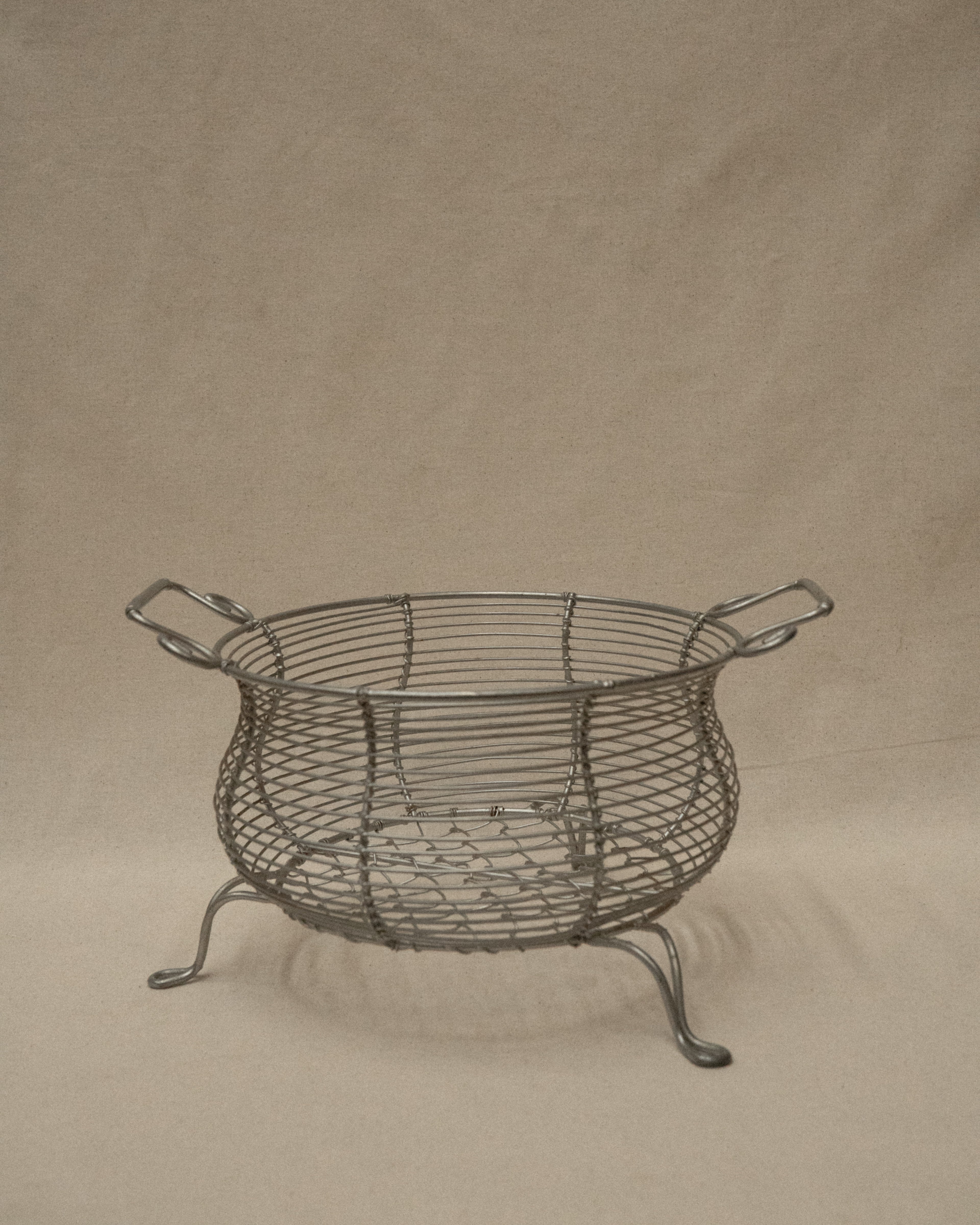 Wire metal basket with two handles and feet