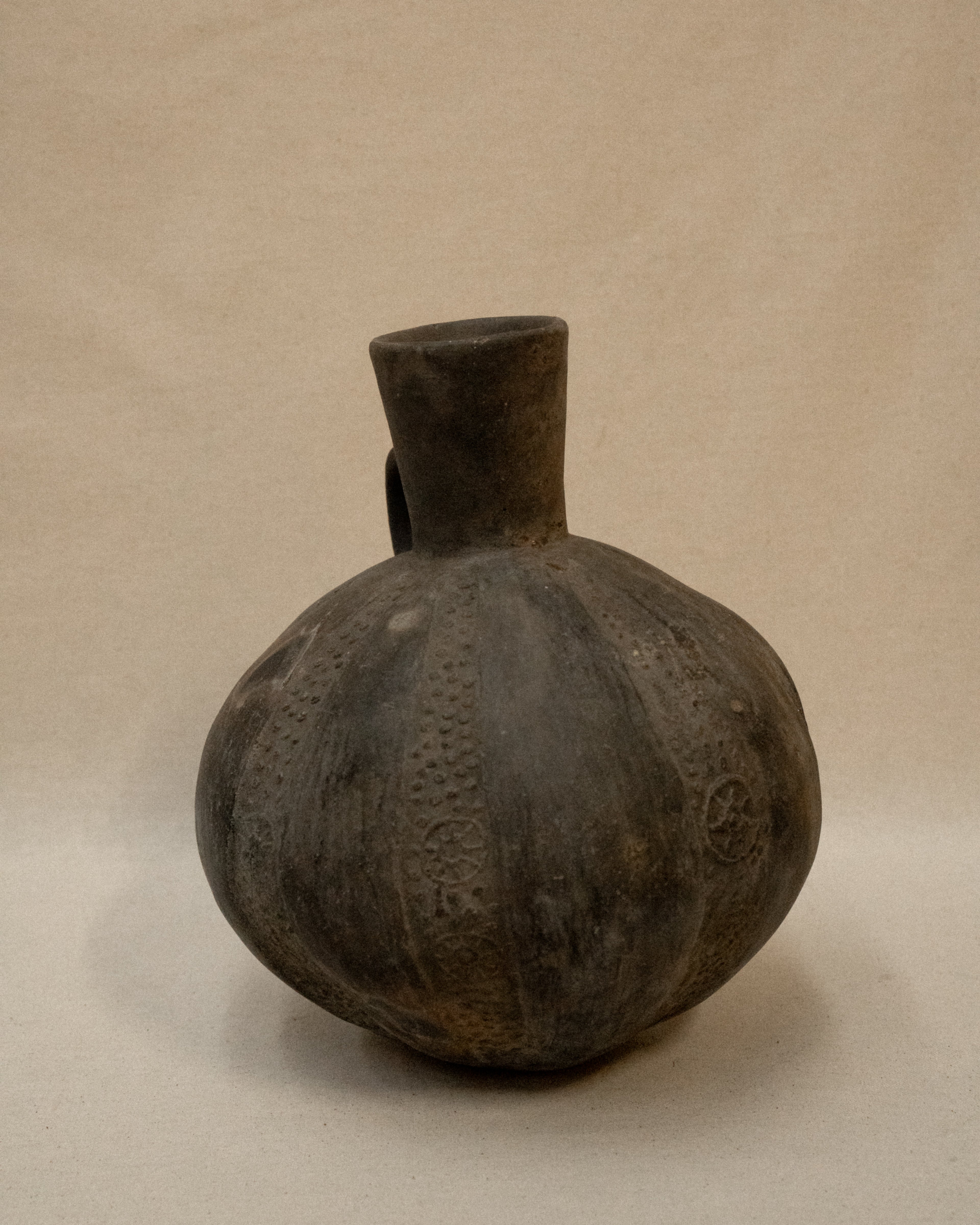 A Pre-Columbian Chimu blackware gourd shaped vessel with handle at the neck