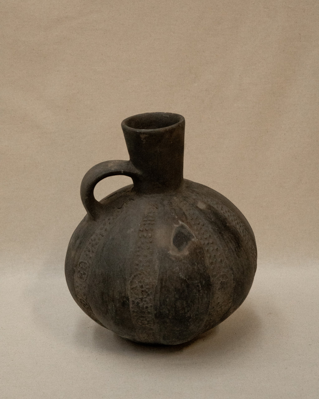 A Pre-Columbian Chimu blackware gourd shaped vessel with handle at the neck
