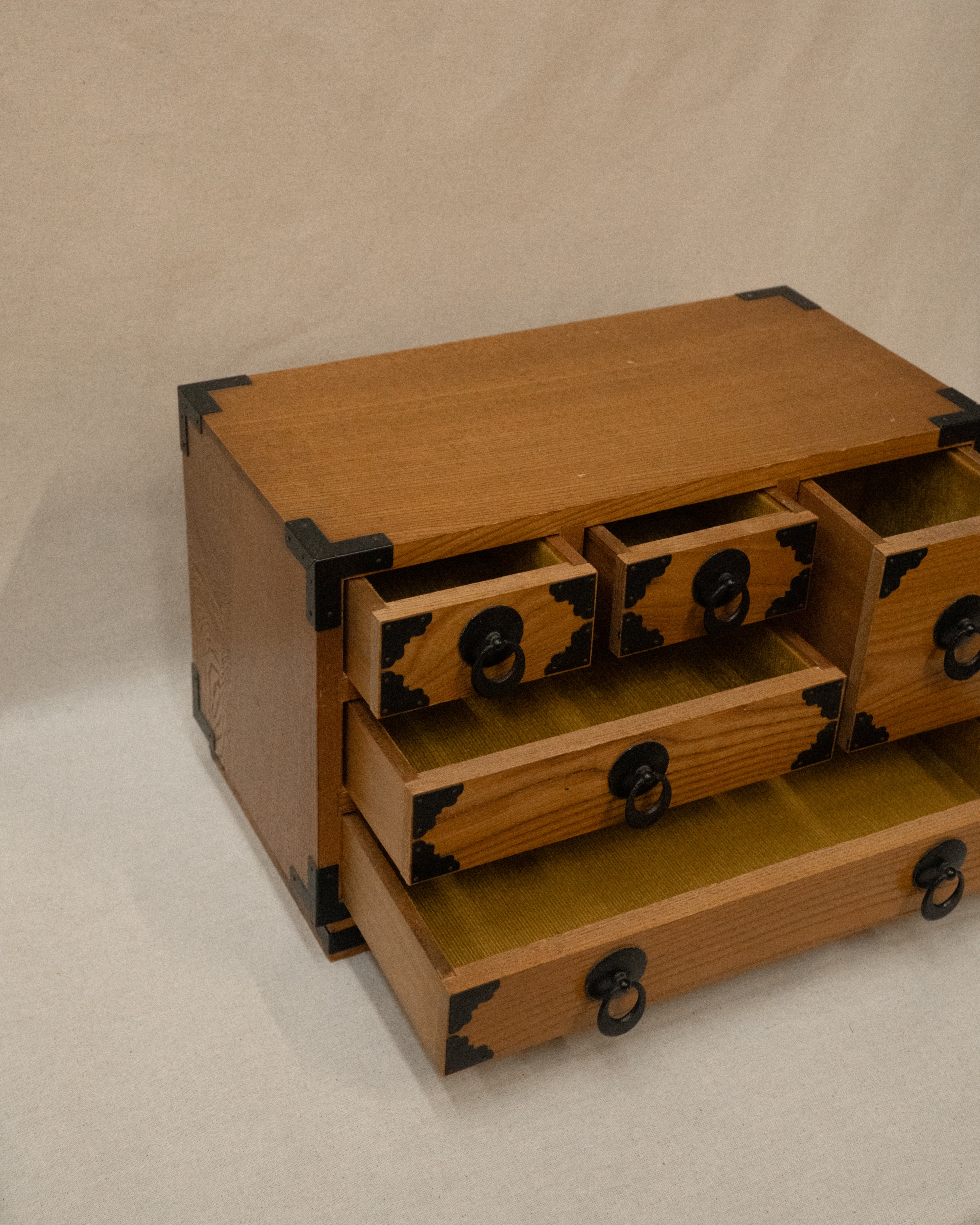 Japanese wooden chest of drawers lined with yellow fabric