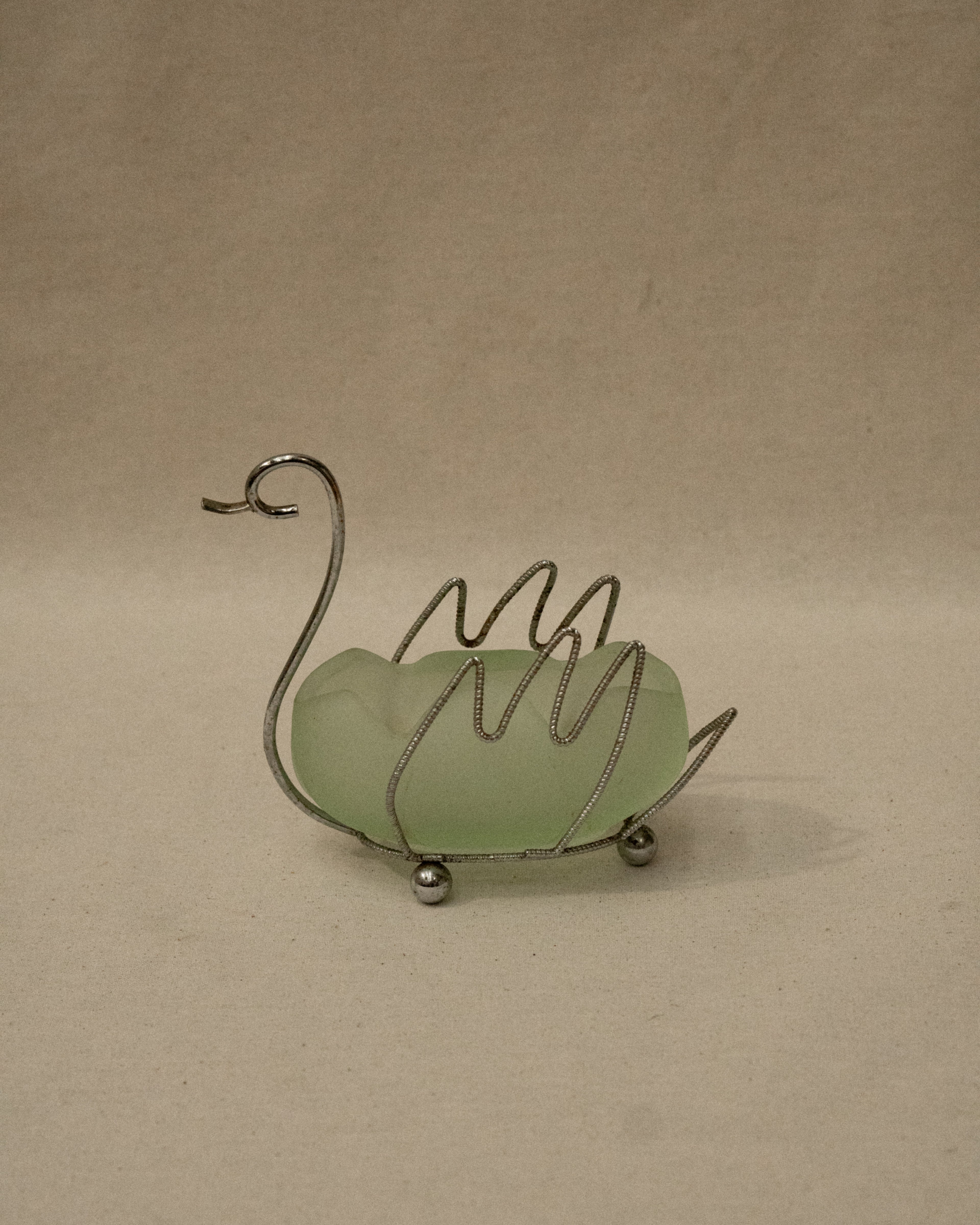 Metal swan with green glass insert