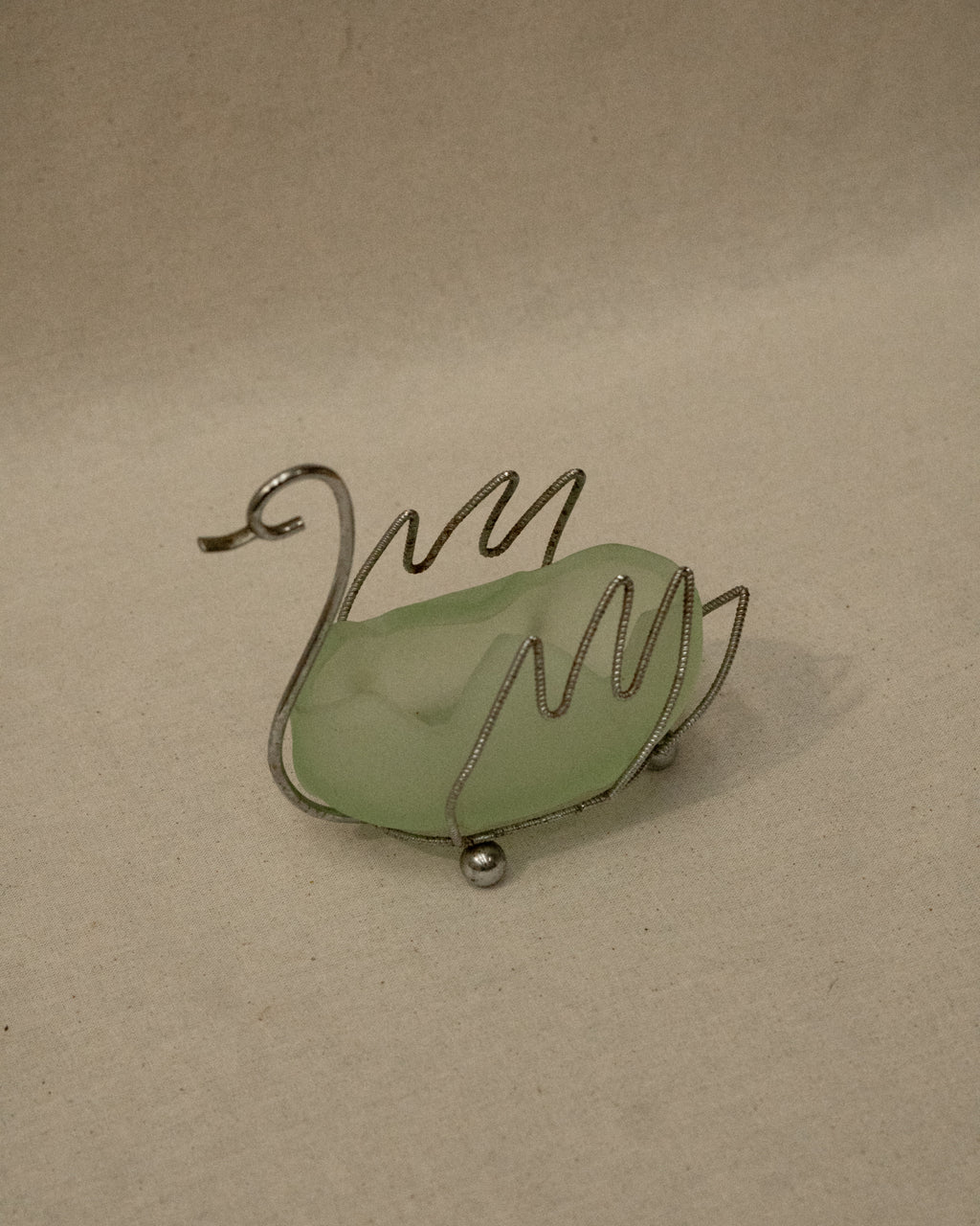 Metal swan with green glass insert