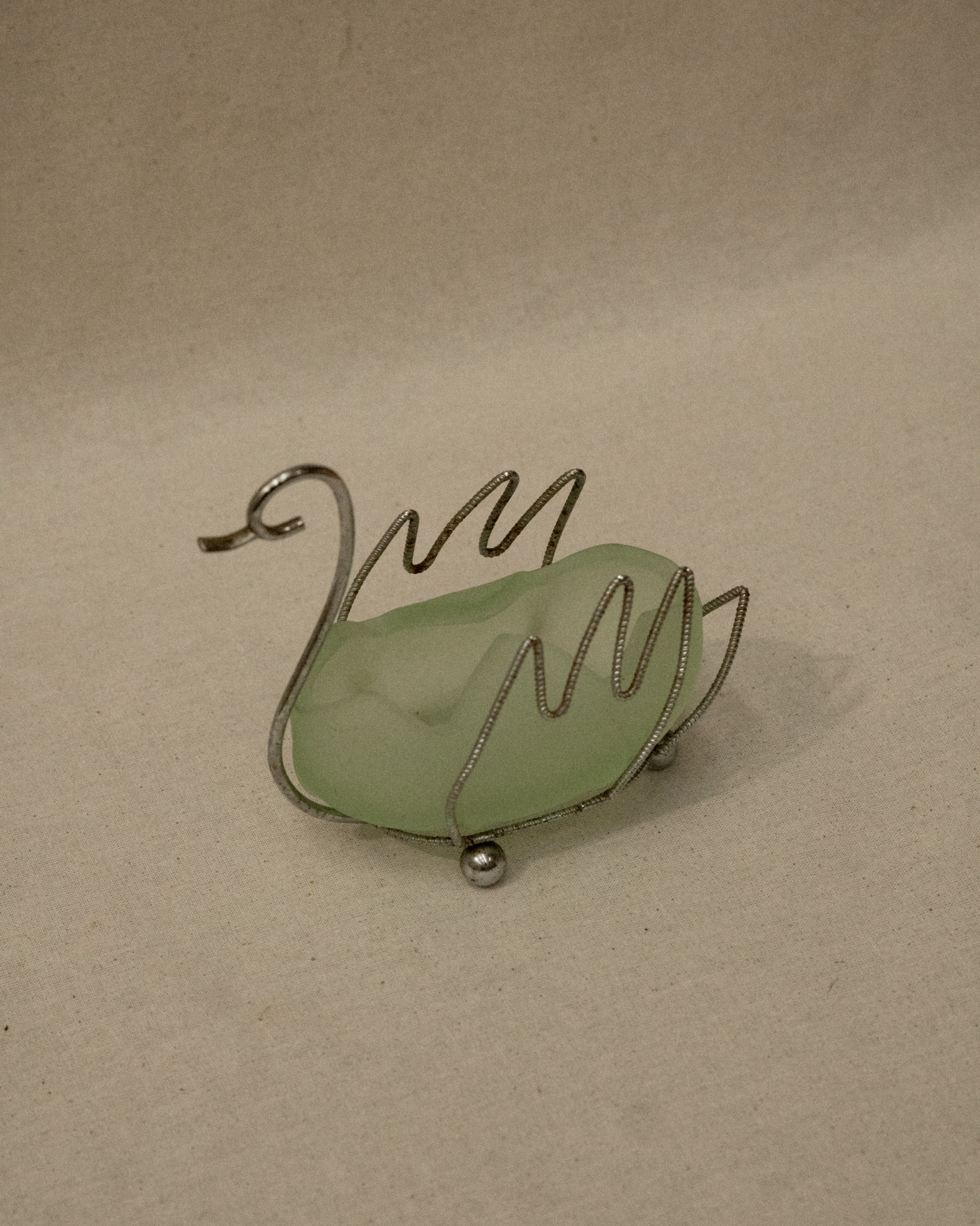 Metal swan with green glass insert