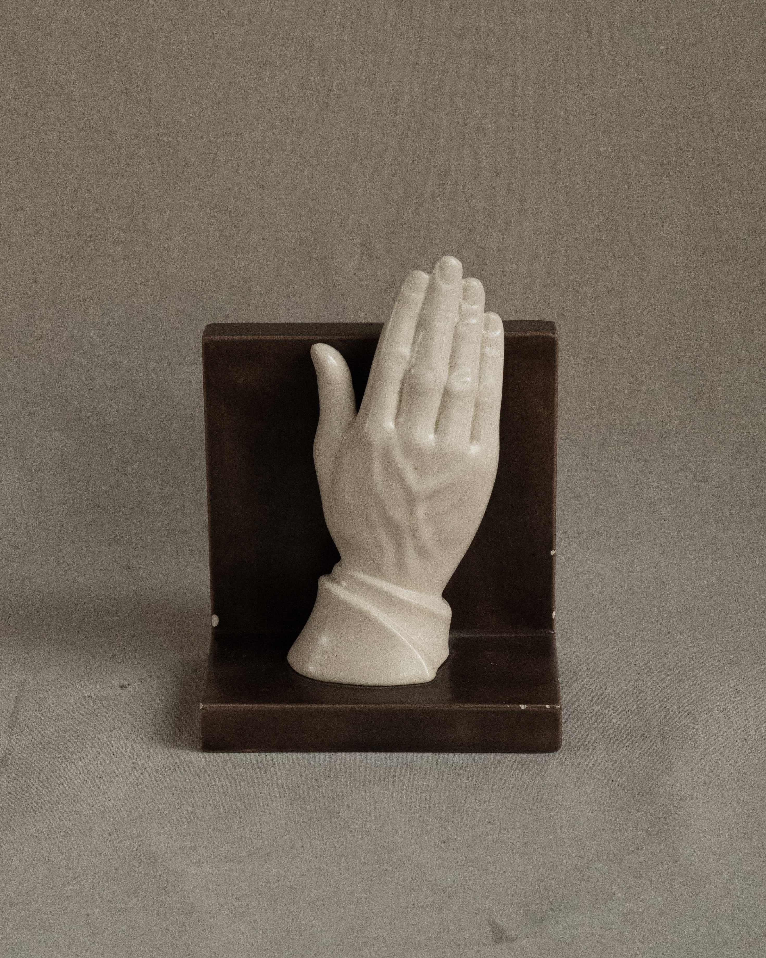 Ceramic taupe bookend with white hand, signed 1985