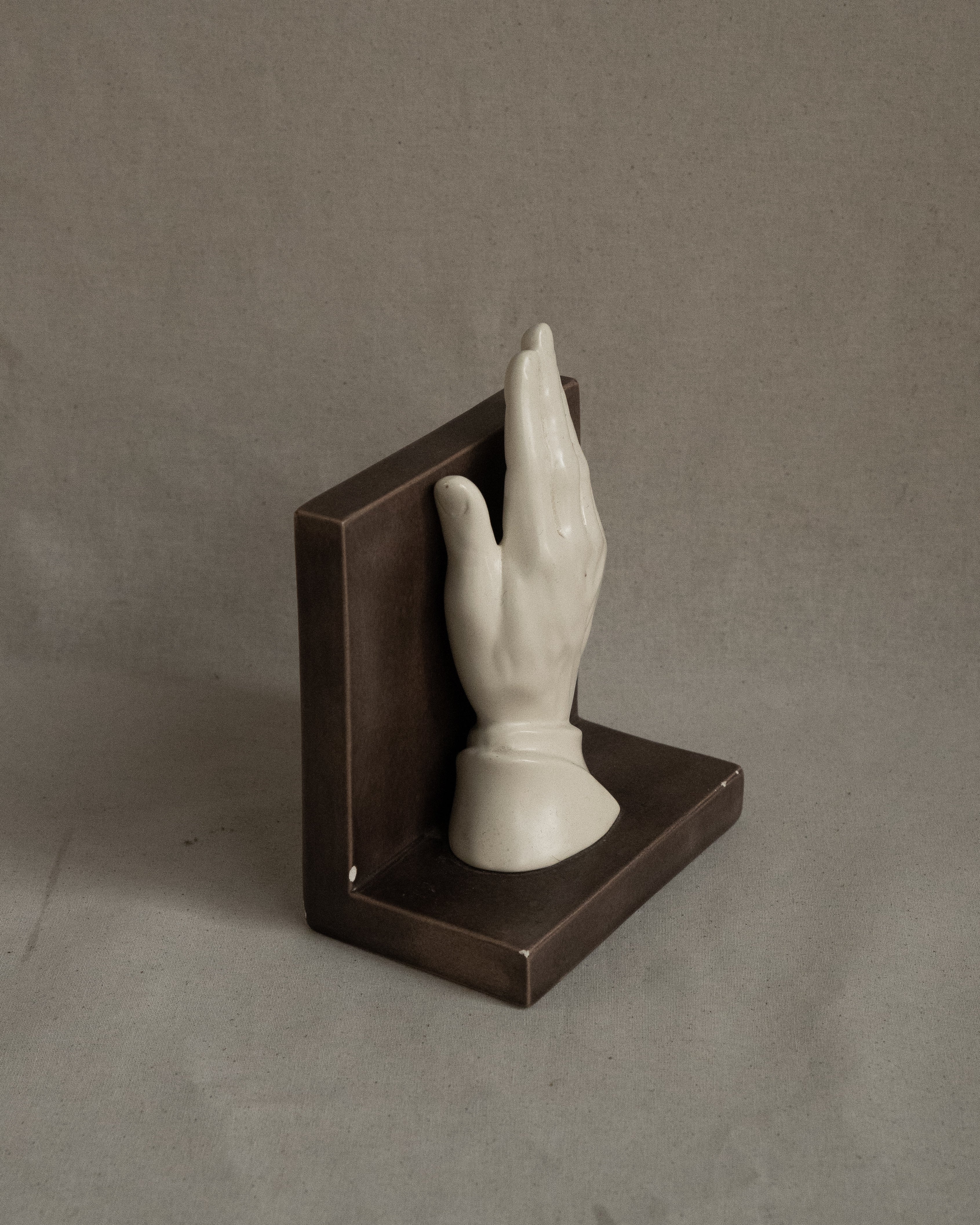 Ceramic taupe bookend with white hand, signed 1985