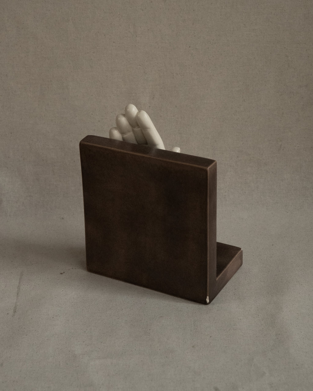 Ceramic taupe bookend with white hand, signed 1985