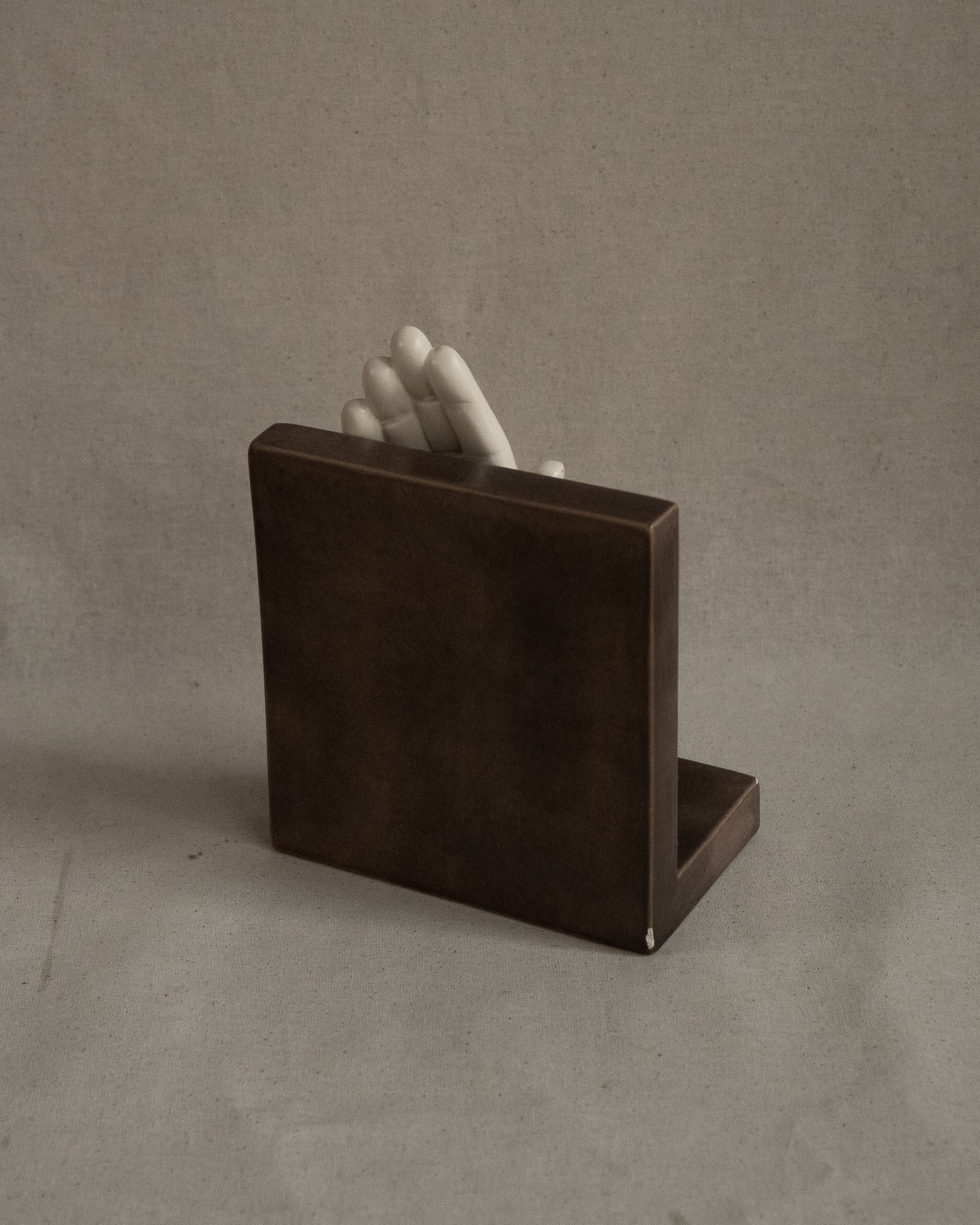 Ceramic taupe bookend with white hand, signed 1985