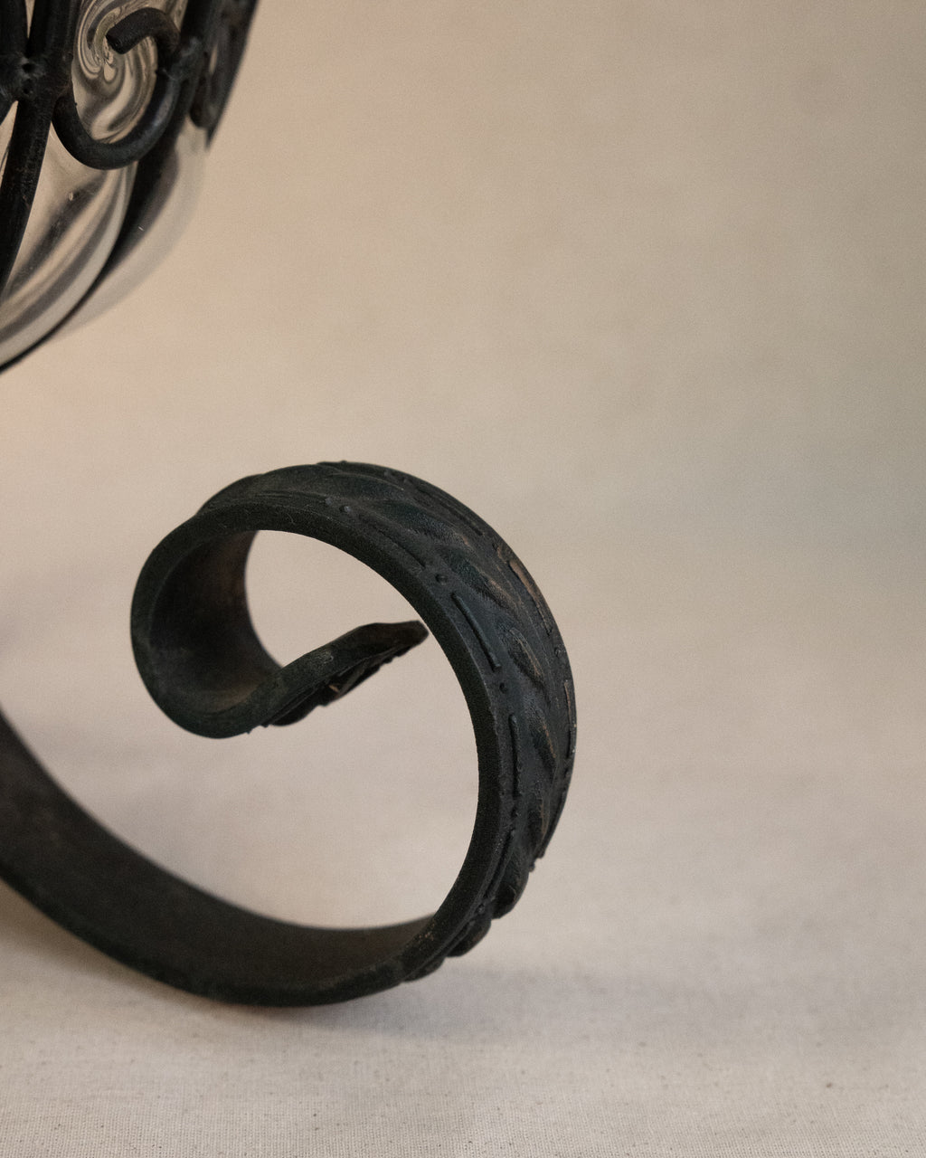Glass bubble vessel in wrought iron cage and spiral feet
