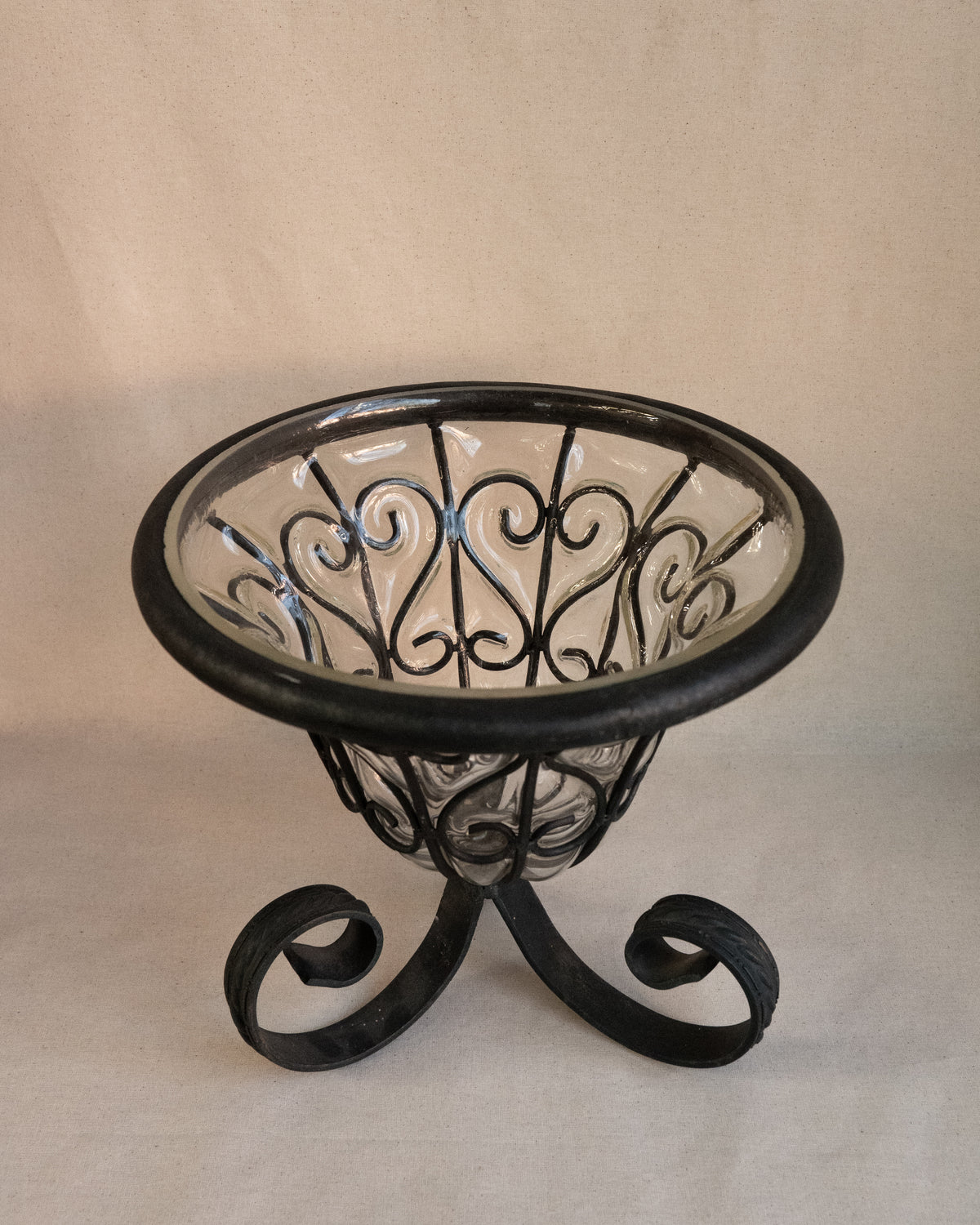 Glass bubble vessel in wrought iron cage and spiral feet