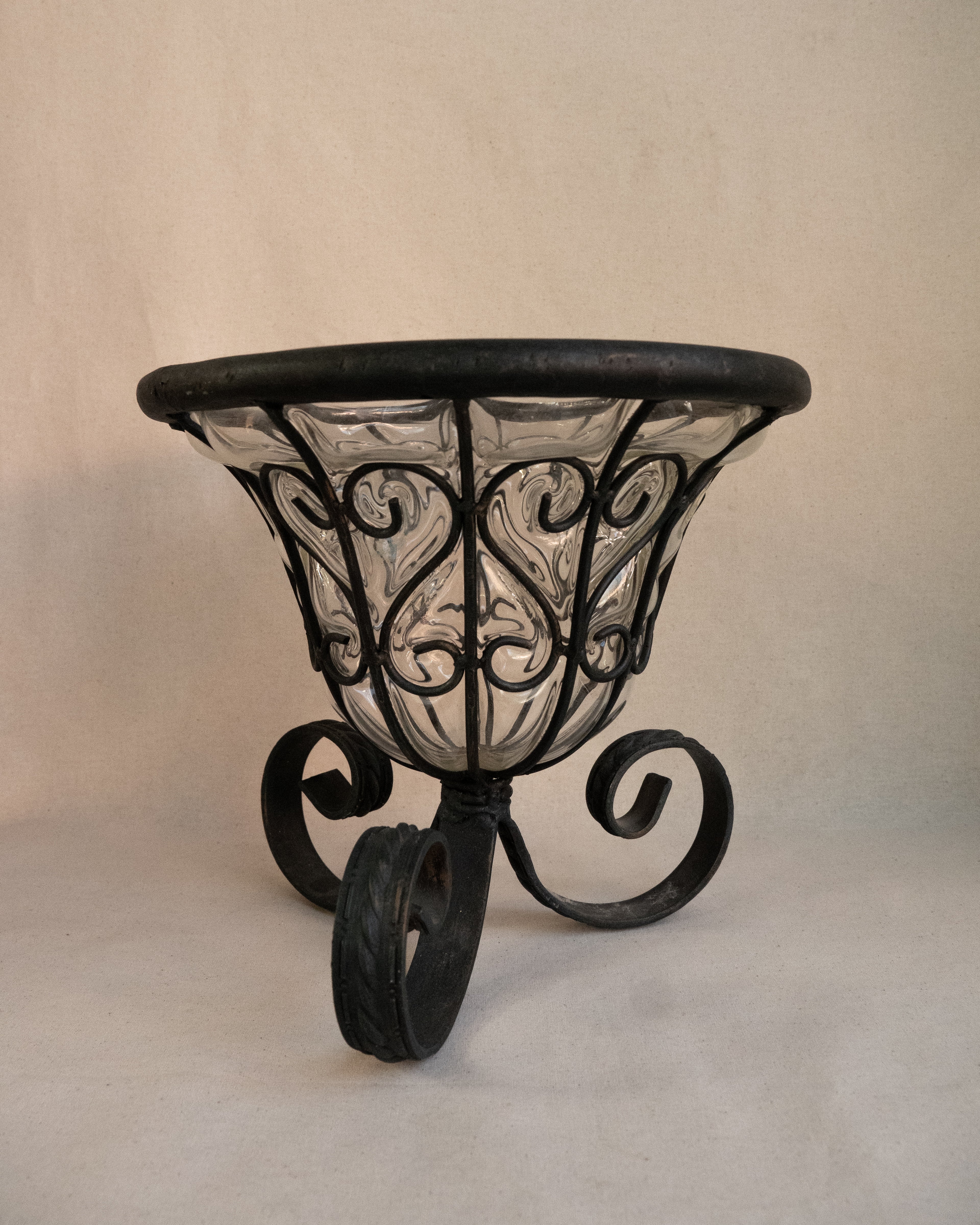 Glass bubble vessel in wrought iron cage and spiral feet