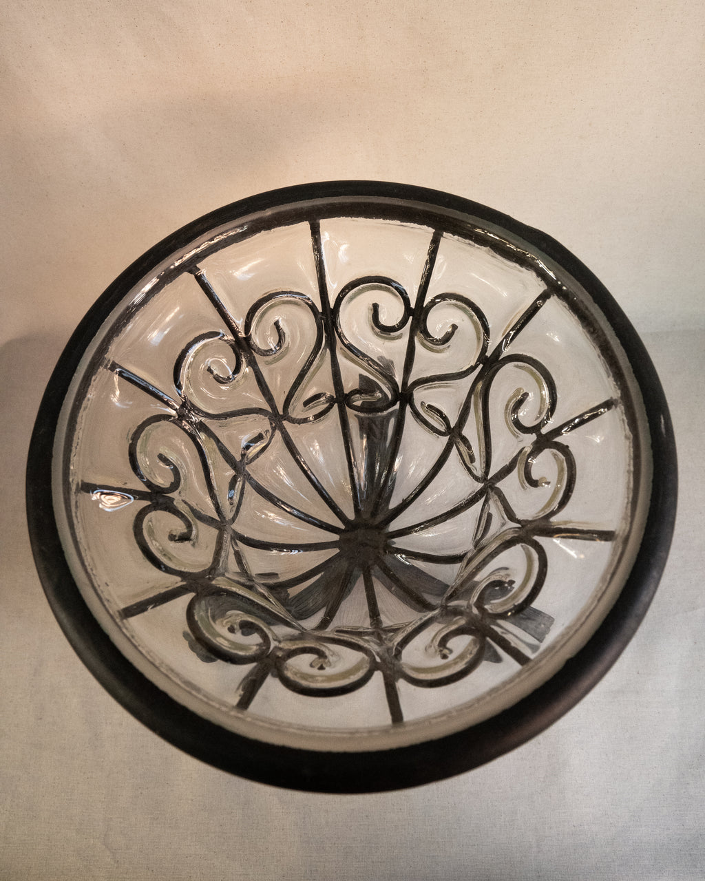 Glass bubble vessel in wrought iron cage and spiral feet