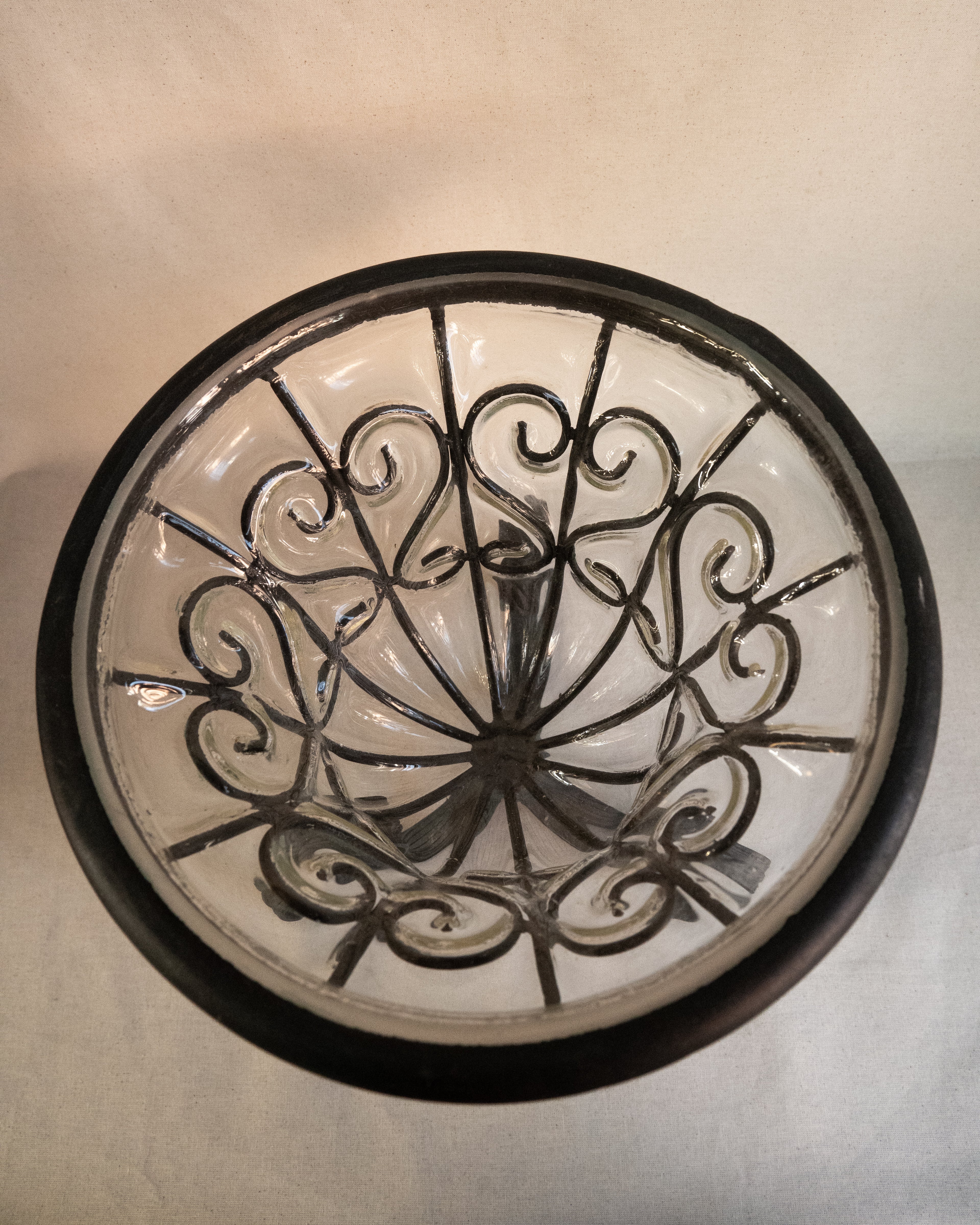 Glass bubble vessel in wrought iron cage and spiral feet