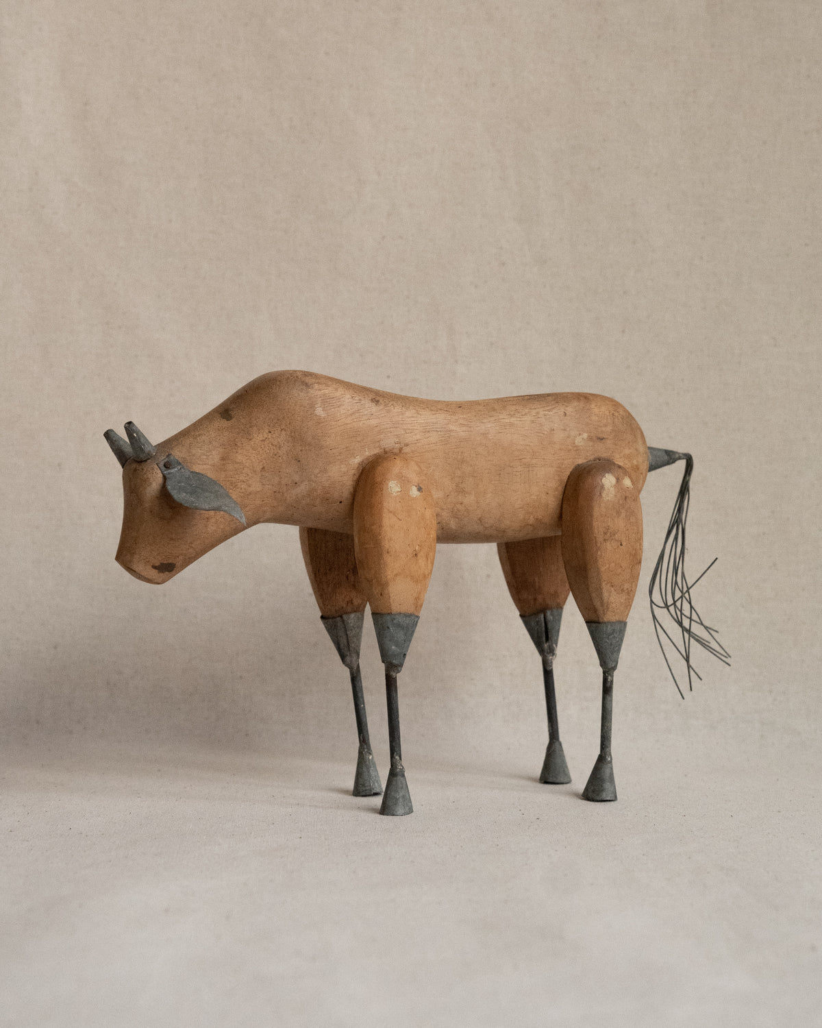Folk art carved wooden bull with metal details