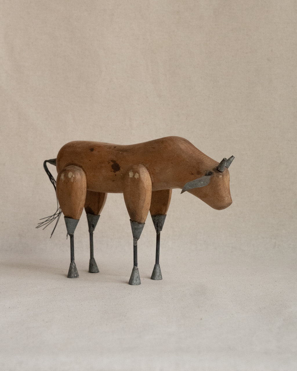 Folk art carved wooden bull with metal details