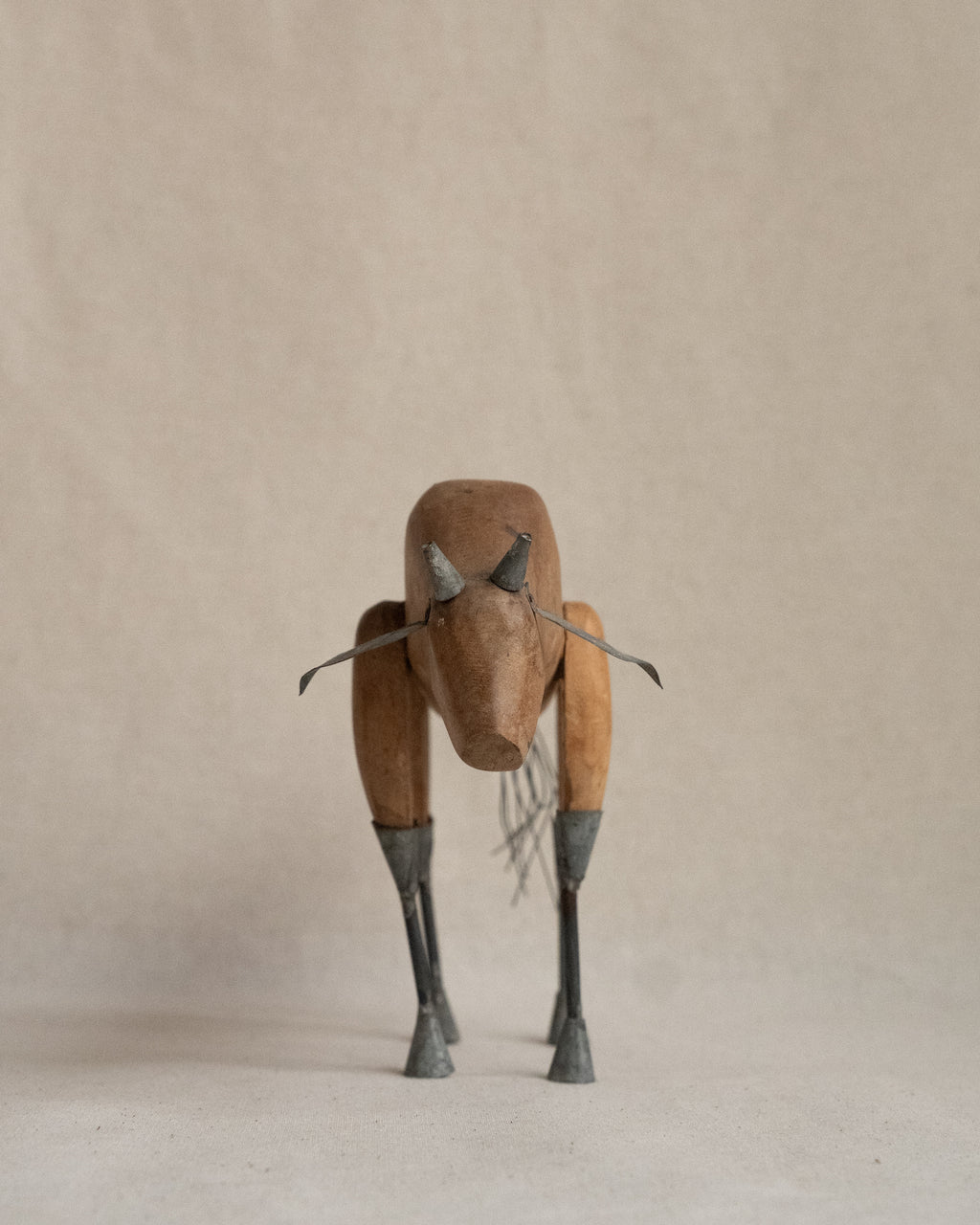 Folk art carved wooden bull with metal details