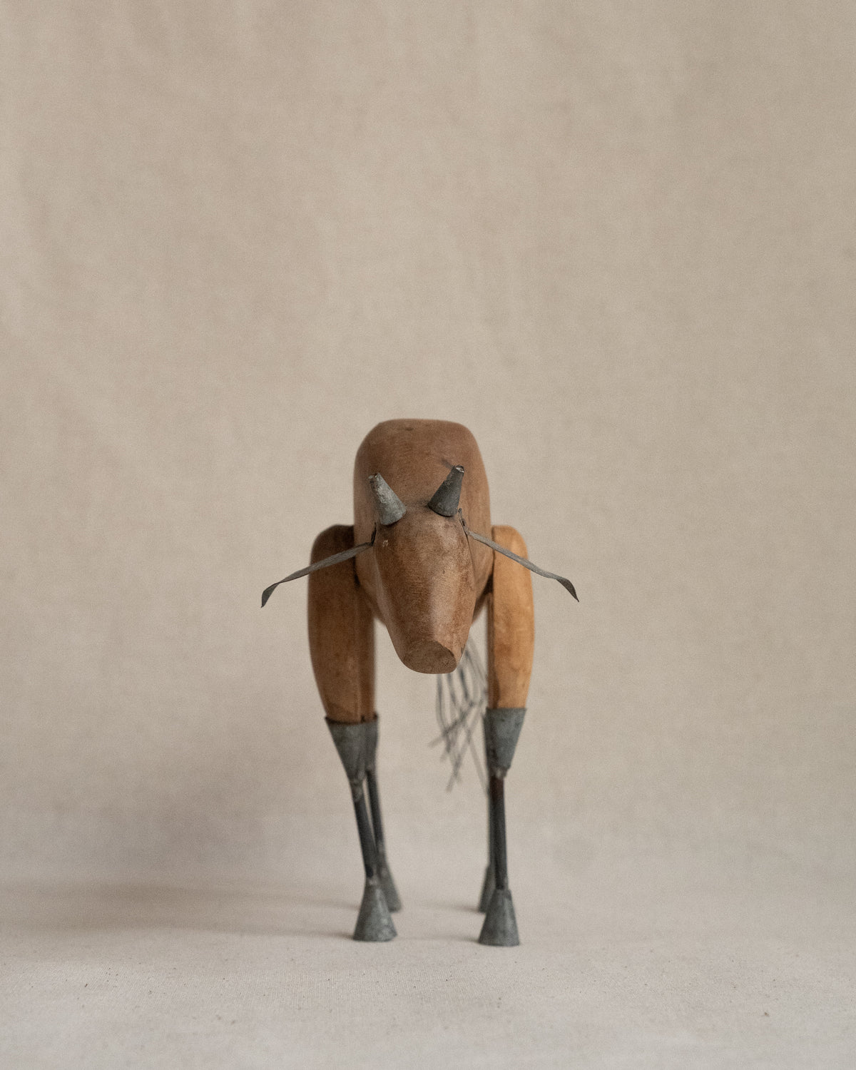 Folk art carved wooden bull with metal details