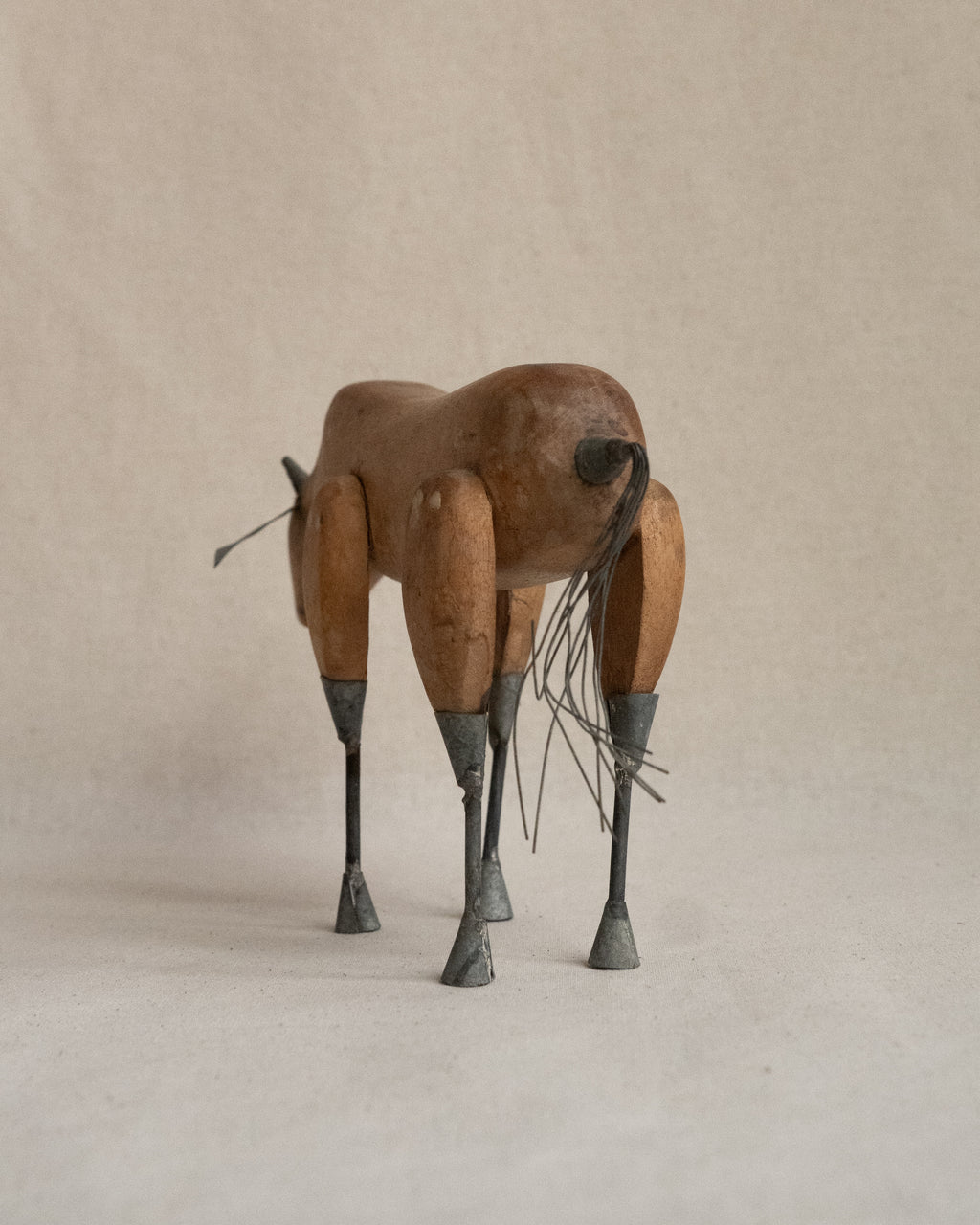 Folk art carved wooden bull with metal details
