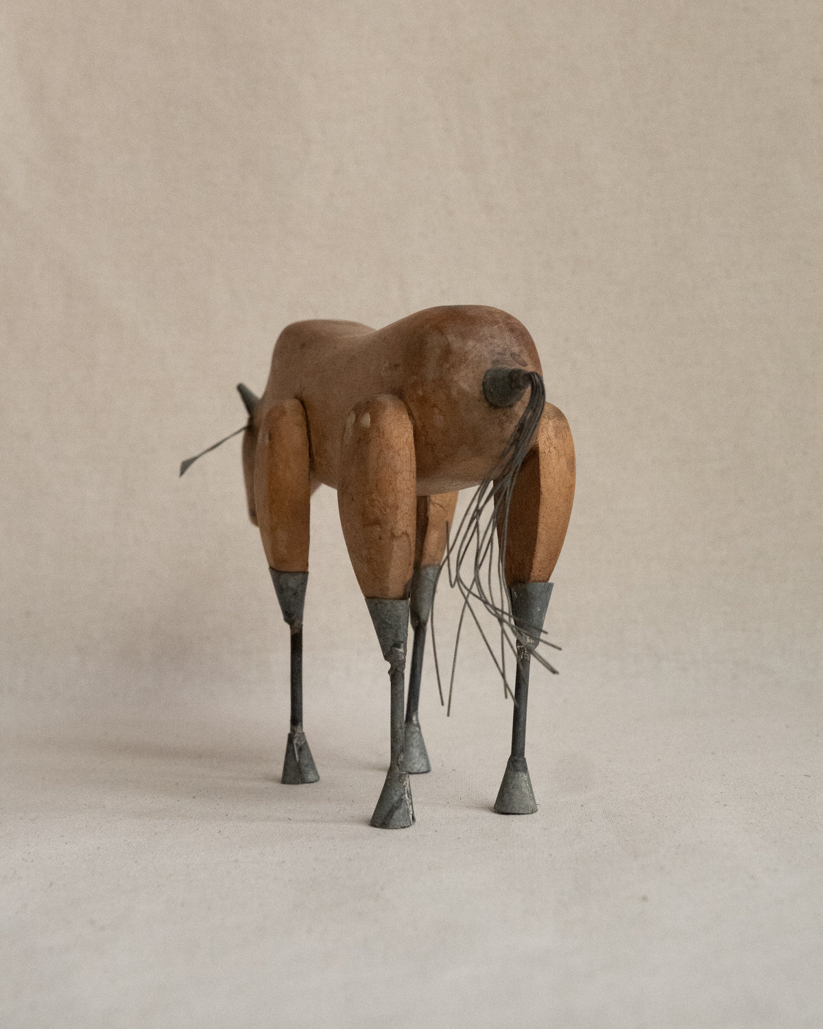 Folk art carved wooden bull with metal details