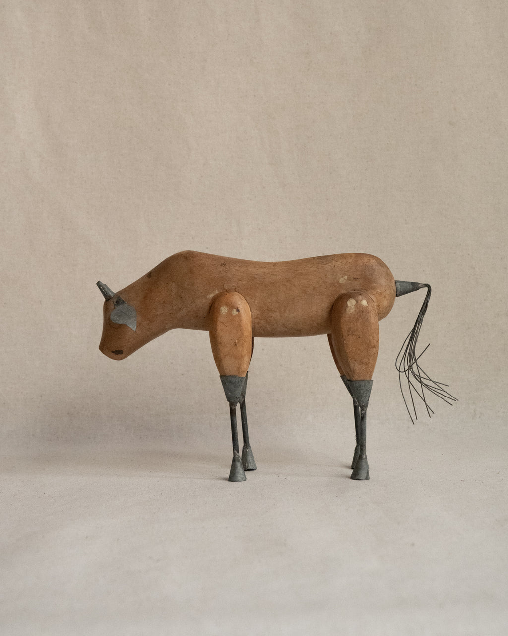 Folk art carved wooden bull with metal details