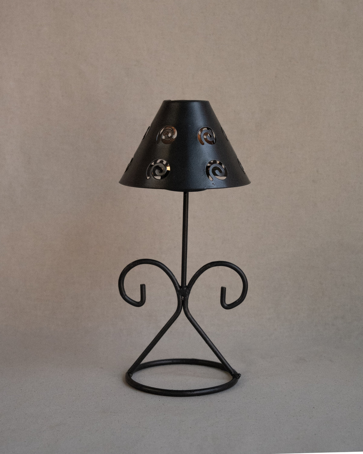 Black metal tea light candle holder with lampshade with spiral cutouts