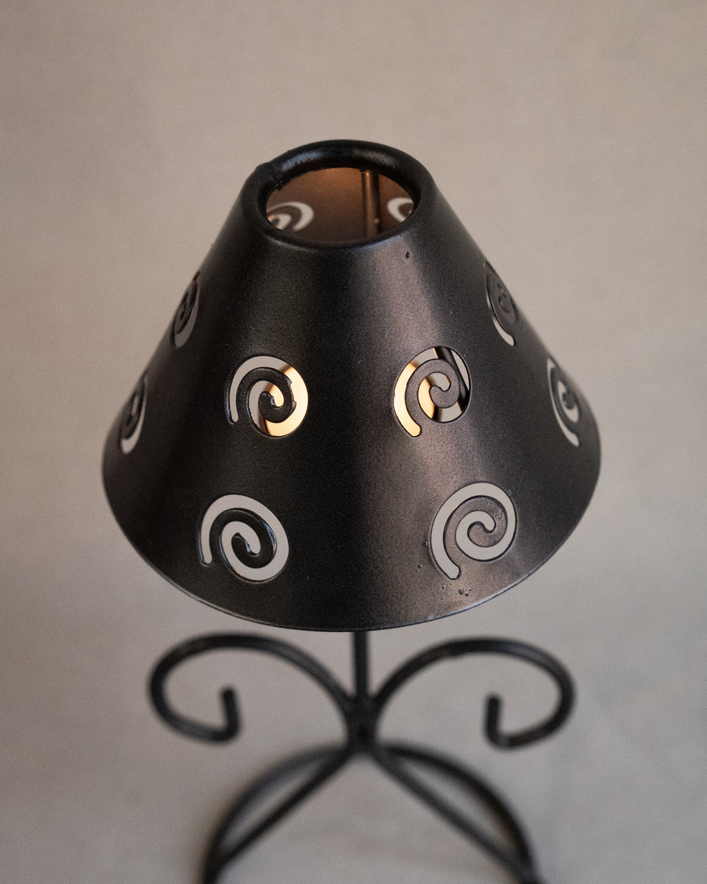 Black metal tea light candle holder with lampshade with spiral cutouts