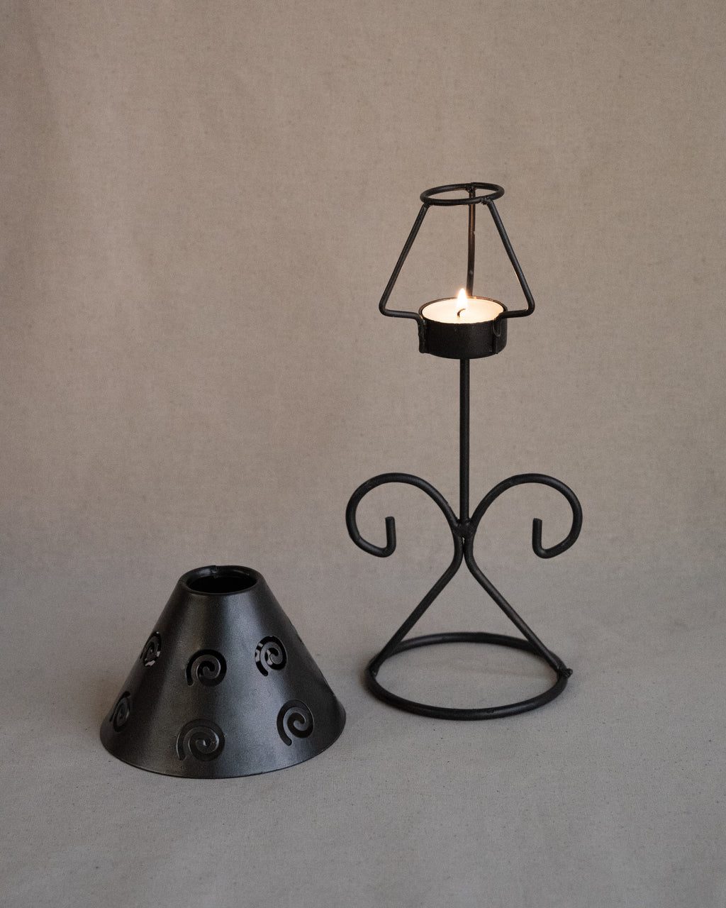 Black metal tea light candle holder with lampshade with spiral cutouts
