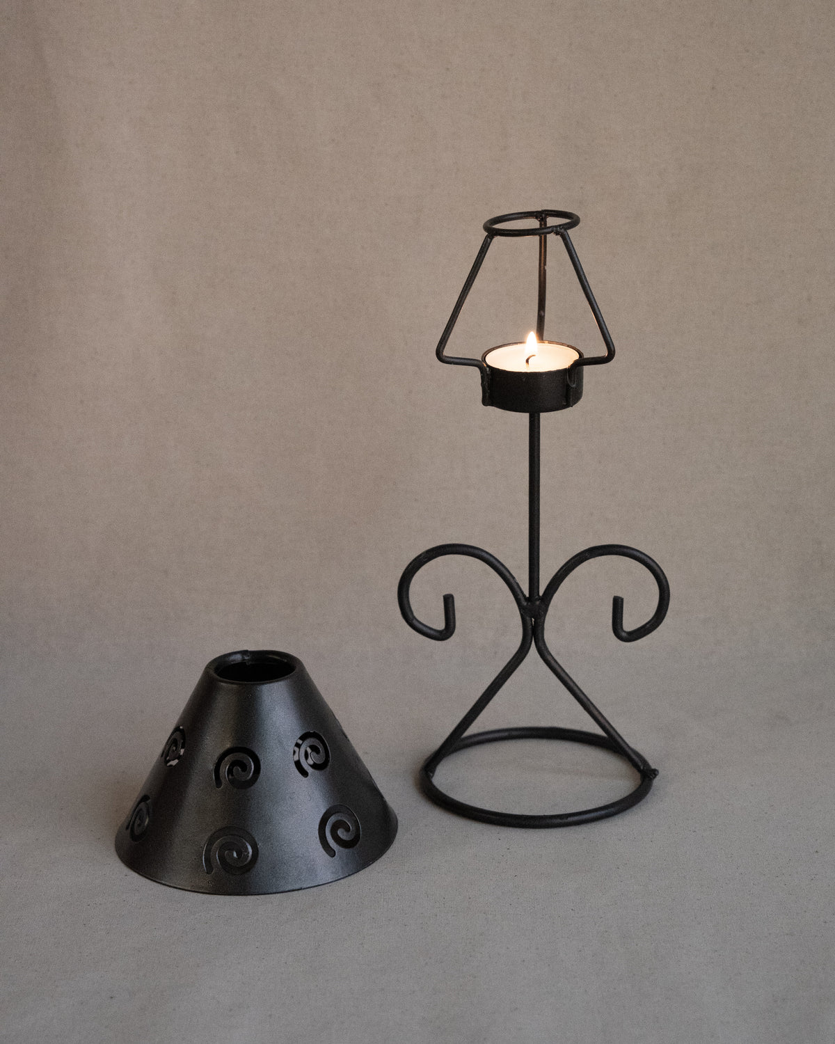 Black metal tea light candle holder with lampshade with spiral cutouts