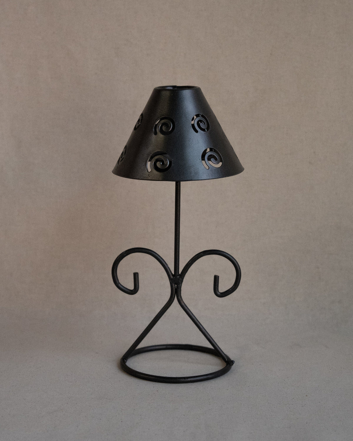 Black metal tea light candle holder with lampshade with spiral cutouts