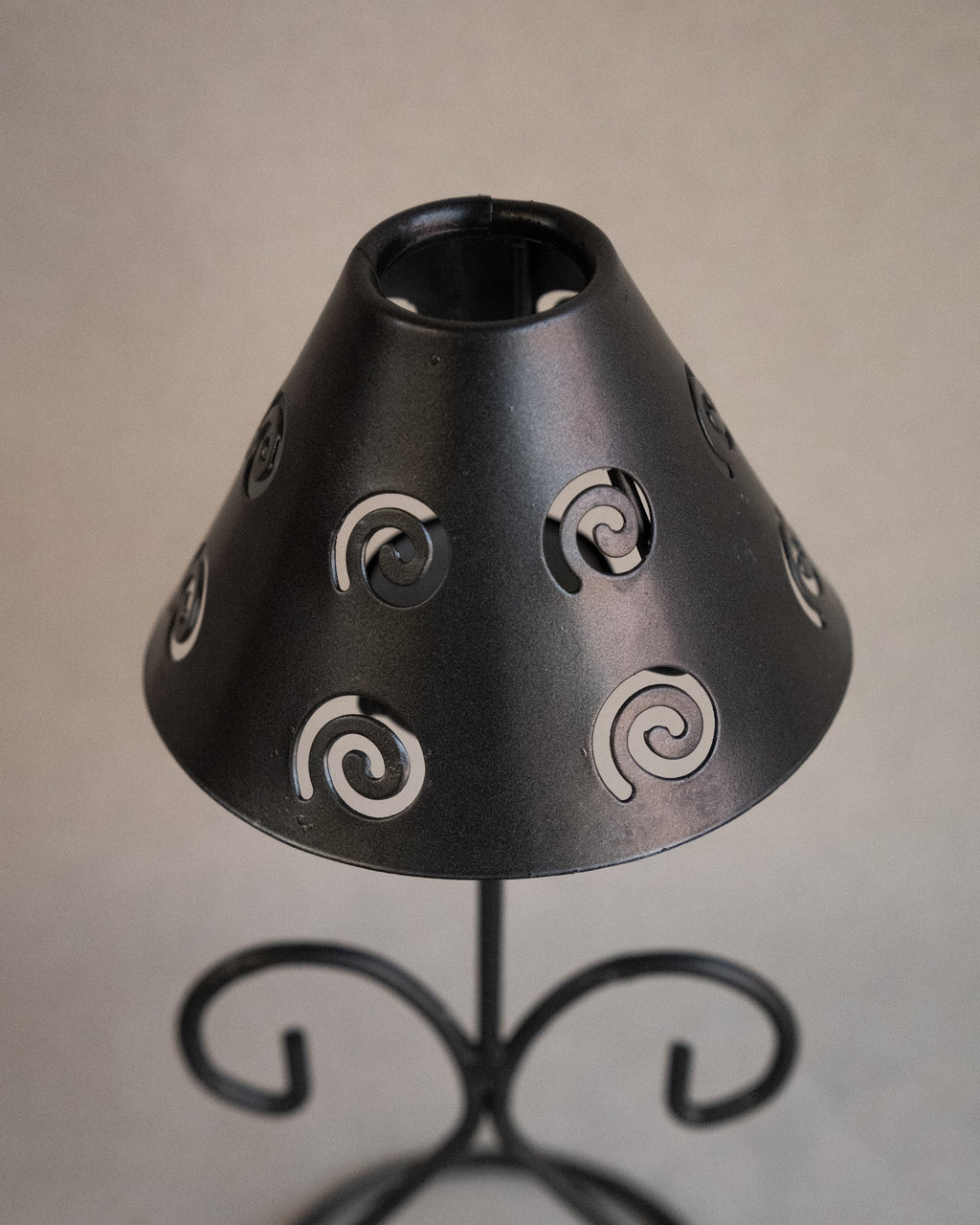 Black metal tea light candle holder with lampshade with spiral cutouts