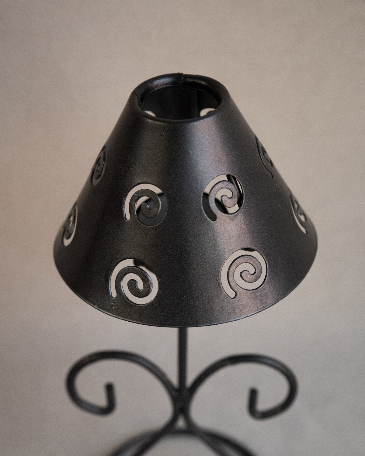 Black metal tea light candle holder with lampshade with spiral cutouts