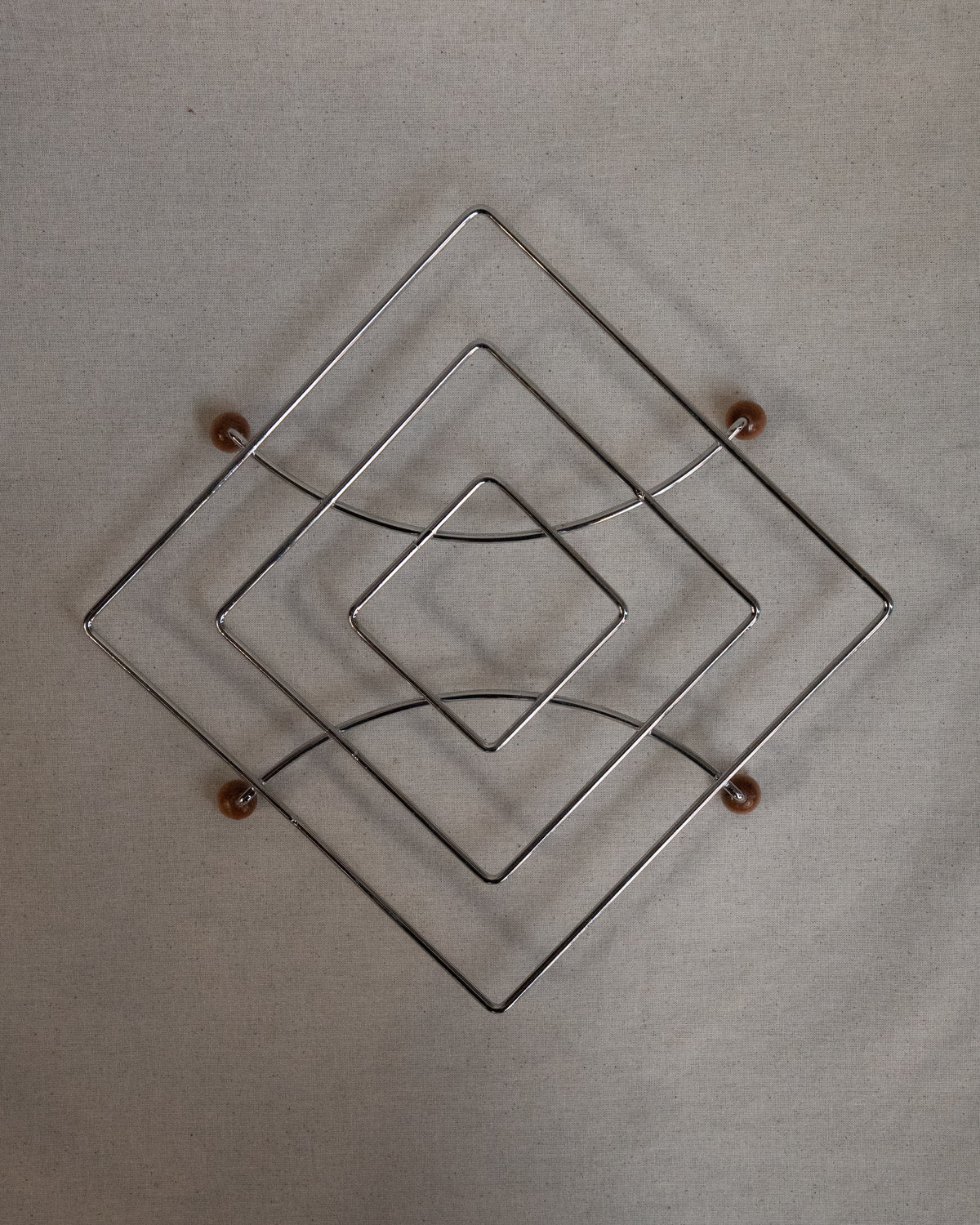 Metal trivet with wooden ball feet
