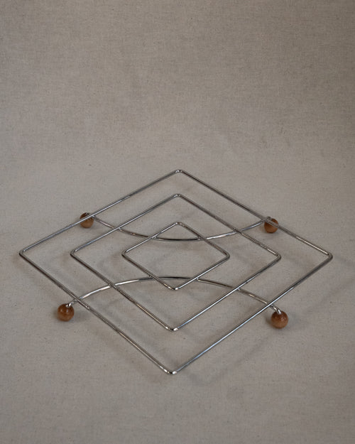 Metal trivet with wooden ball feet