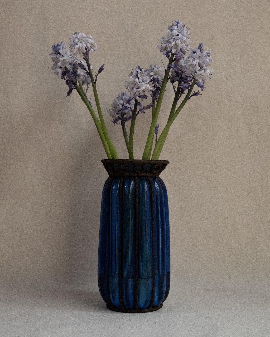 Cobalt blue glass bubble vessel in wrought iron cage vase