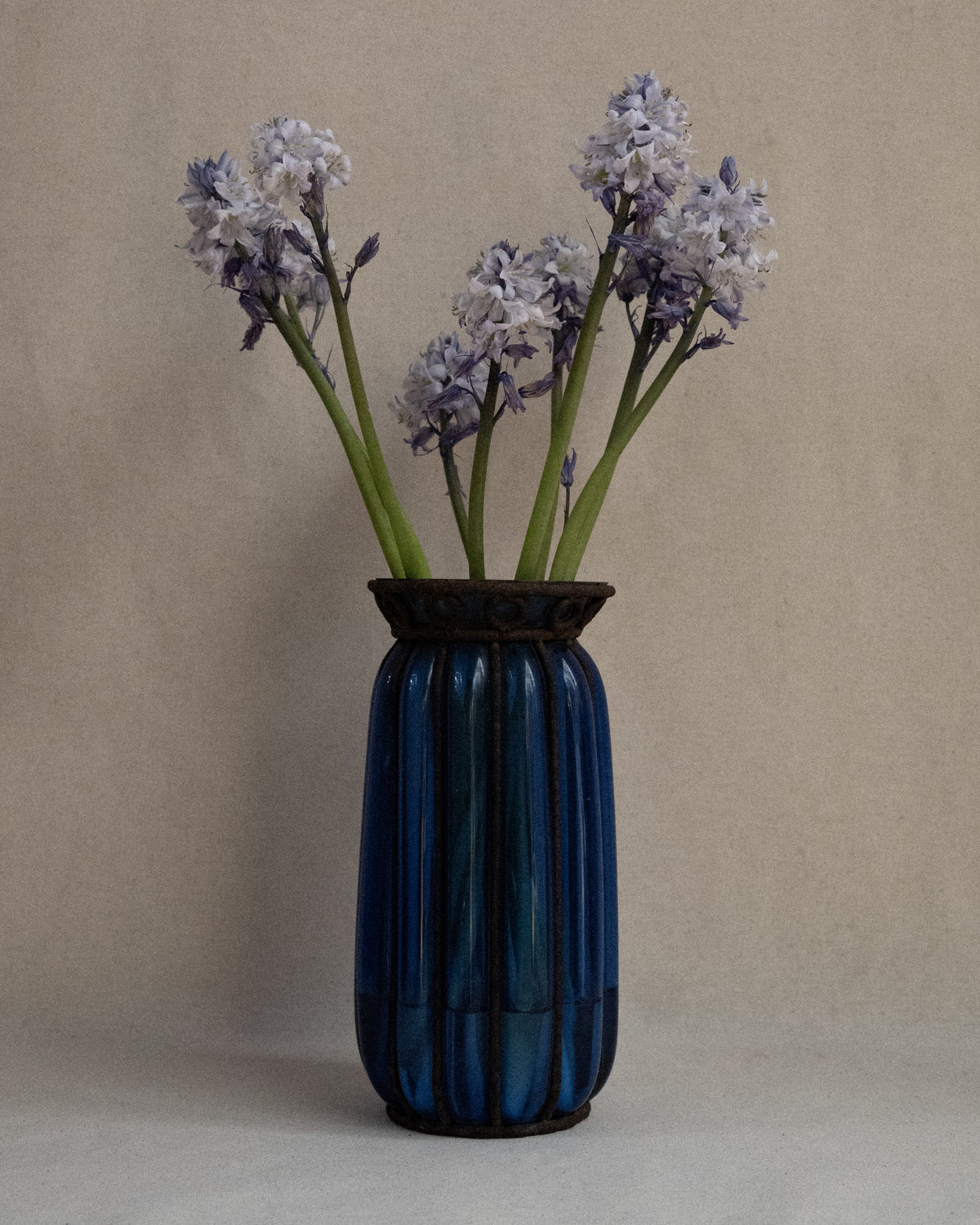 Cobalt blue glass bubble vessel in wrought iron cage vase