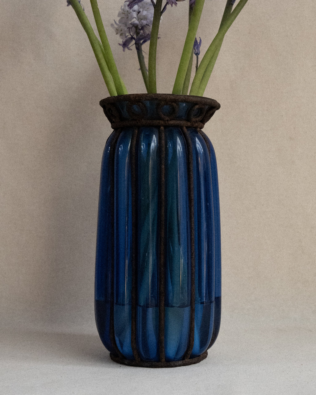 Cobalt blue glass bubble vessel in wrought iron cage vase