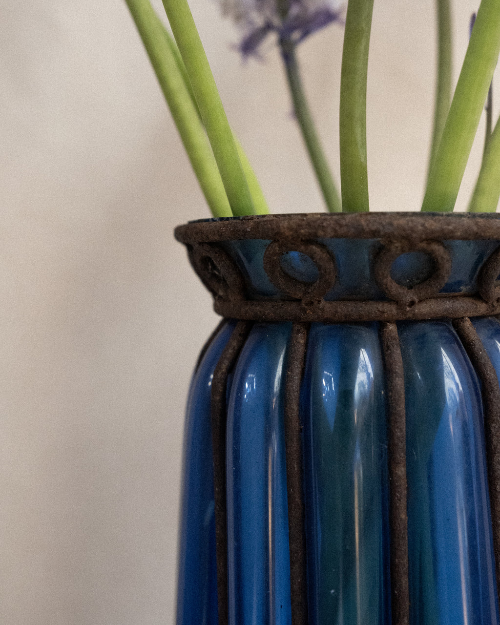 Cobalt blue glass bubble vessel in wrought iron cage vase