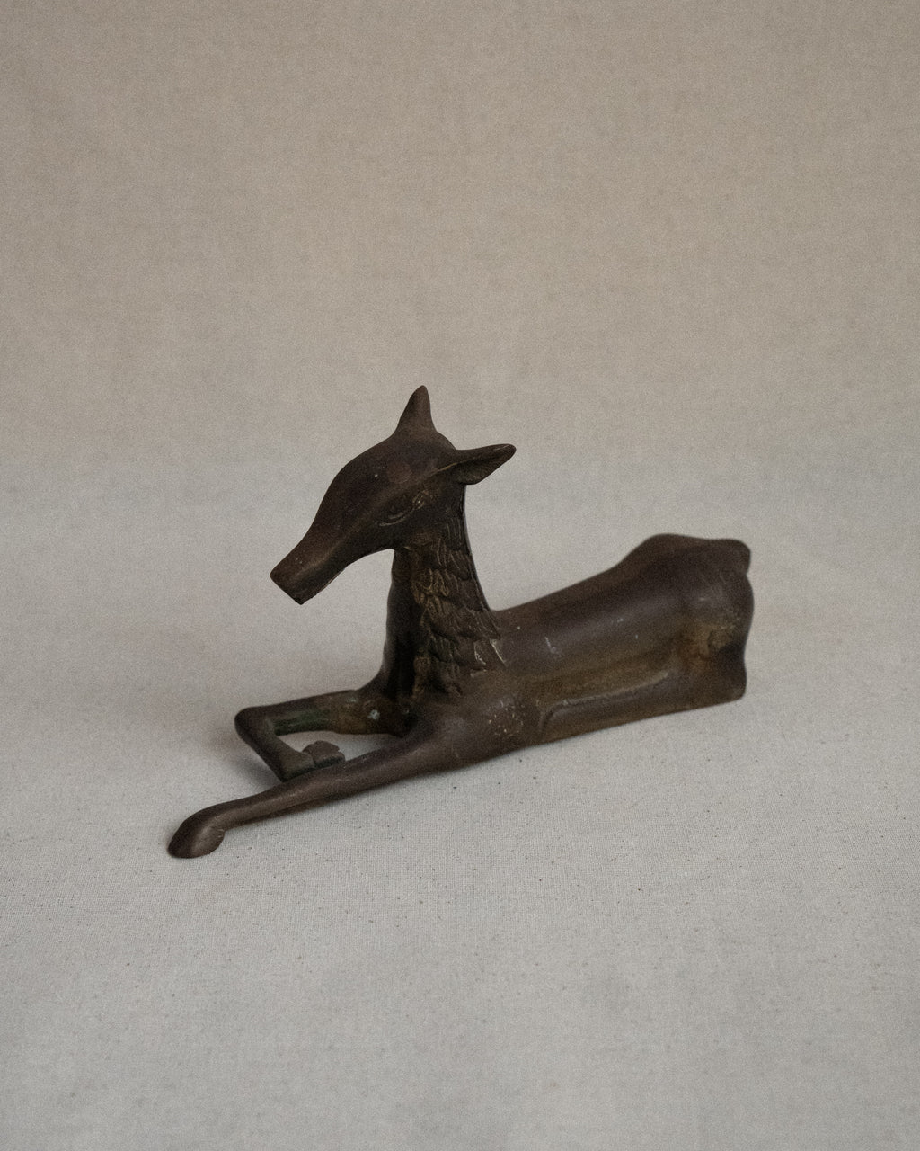 Brass deer sitting sculpture