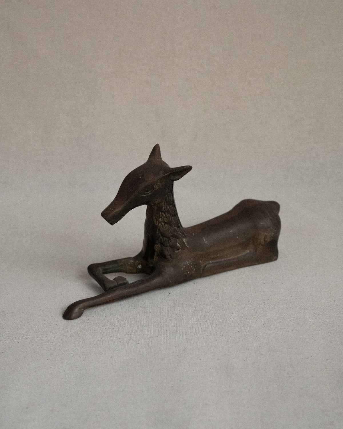 Brass deer sitting sculpture