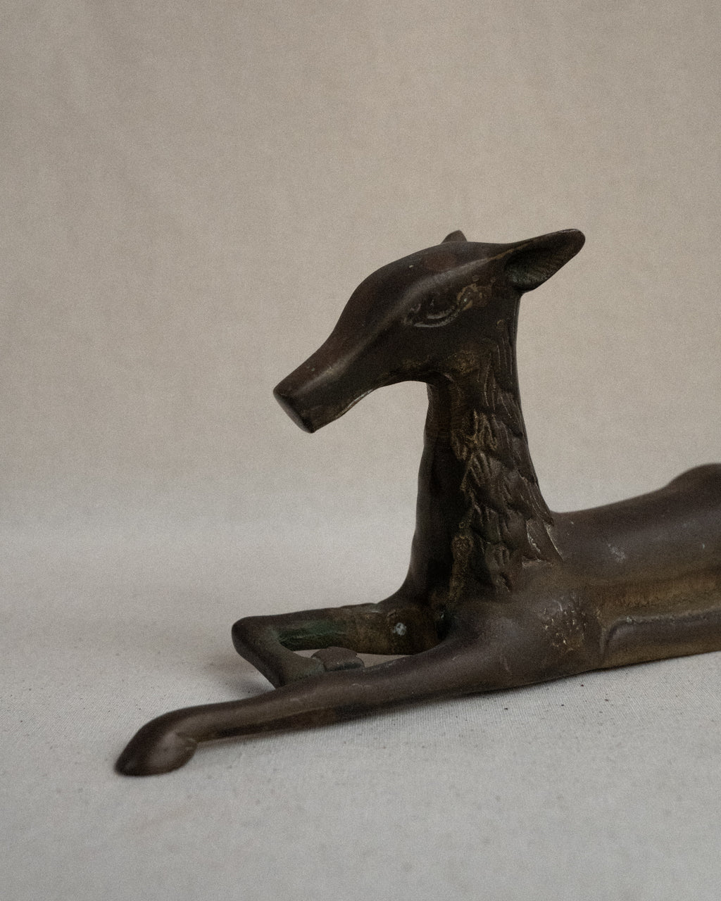 Brass deer sitting sculpture